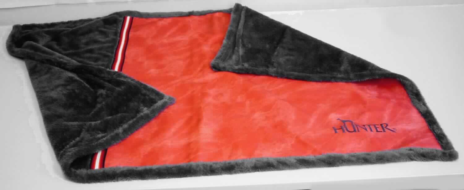 Decke, sog. Hundedecke Göteborg rot, Art. 65087, Foto siehe Anlage, 
- in einem Polybeutel verpackt, 
- annähernd rechteckig; laut Antrag in den Abmessungen: 120 cm x 80 cm,
- zweilagig gearbeitet, mit einer flächenmäßig überwiegenden, charakterbestimmenden Ober- und Unterlage aus 
  ca. 1,2 mm dicken, einfarbigen Plüschgewirken aus laut Antrag 100 % Polyester (synthetische Chemiefasern); 
  auf einer Seite mit einem 75 cm x 75 cm großen, dreilagigen Einsatz (Flächenerzeugnis der Position 5903) mit 
  einer Oberlage aus in Gewebeoptik bedruckten Kunststofffolien, einer Zwischenlage aus augenscheinlich 
  Zellkunststoff und einer Unterlage aus gerauten, nicht nur der Verstärkung dienenden Gewirken, 
- ohne elektrische Heizvorrichtung, 
- durch Zusammennähen konfektioniert, 
- ohne Polsterung oder Füllung; somit keine Ware der Position 9404, 
- soll laut Antrag als Liegedecke für Tiere dienen, 
- nicht zur Ausstattung von Tieren bestimmt, somit keine Ware i. S. d. Position 4201.

"Decke, aus Spinnstoffen, ohne elektrische Heizvorrichtung, aus synthetischen Chemiefasern, aus Gewirken"
