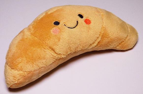 Bei dem sog. Wärmekissen Kawaii, Art. 402296 handelt es sich um ein ca. 21 cm x 9,5 cm x 7,5 cm (L x B x H) großes, rundes, leicht gebogenes Kissen in Form eines Croissants mit aufgesticktem Gesicht, mit einer Hülle aus hellbraunen Spinnstoffgewirken sowie einer zweilagigen Füllung, bestehend aus Wattierungsstoff (obere Lage) und ca. 2 mm großen braunen Keramikkügelchen (untere Lage).
 
Das Erzeugnis dient als Wärmekissen (wird bspw. in der Mikrowelle aufgewärmt) und kann für Anwendungen zur Steigerung des Wohlbefindens und zur Linderung von körperlichen Beschwerden eingesetzt werden.
 
Die Ware ist als „den Bettausstattungen ähnliche Ware, gepolstert, nicht von den Unterpositionen (HS) 9404 21 bis 9404 40 erfasst, nicht mit Federn oder Daunen gefüllt“ einzureihen.