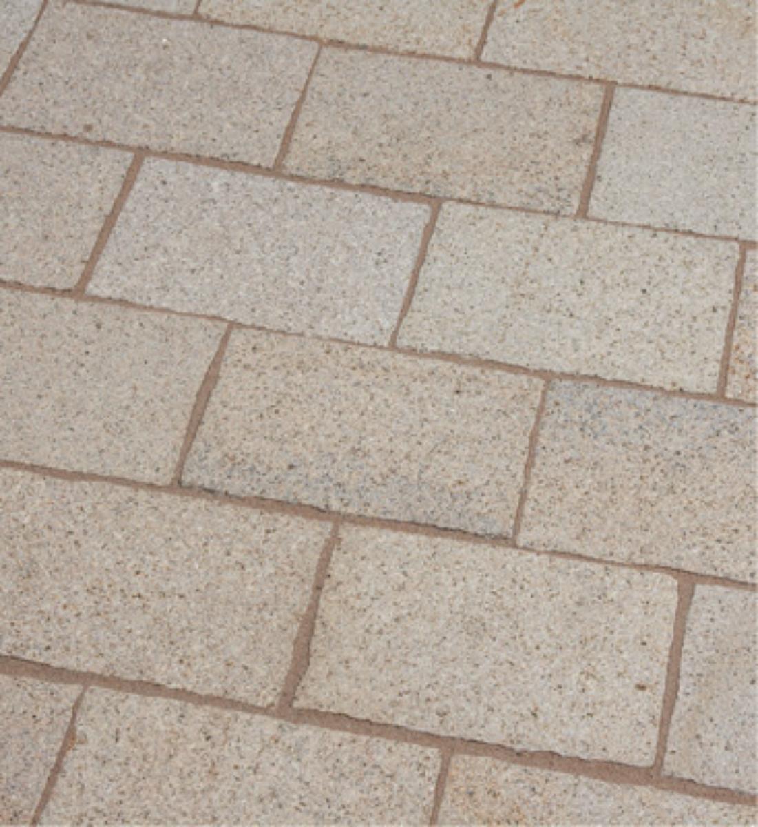 Angaben:
Pflasterplatten SOL AMBIENTE gestockt; Bearbeitung: Oberfläche gesägt und gestockt, Seiten handbekantet, Unterseite gesägt und mit Stock/Spitzeisen aufgeraut; Material: Granit; Farbe: gelb-grau.

Befund:
Pflasterplatten, aus Naturstein.