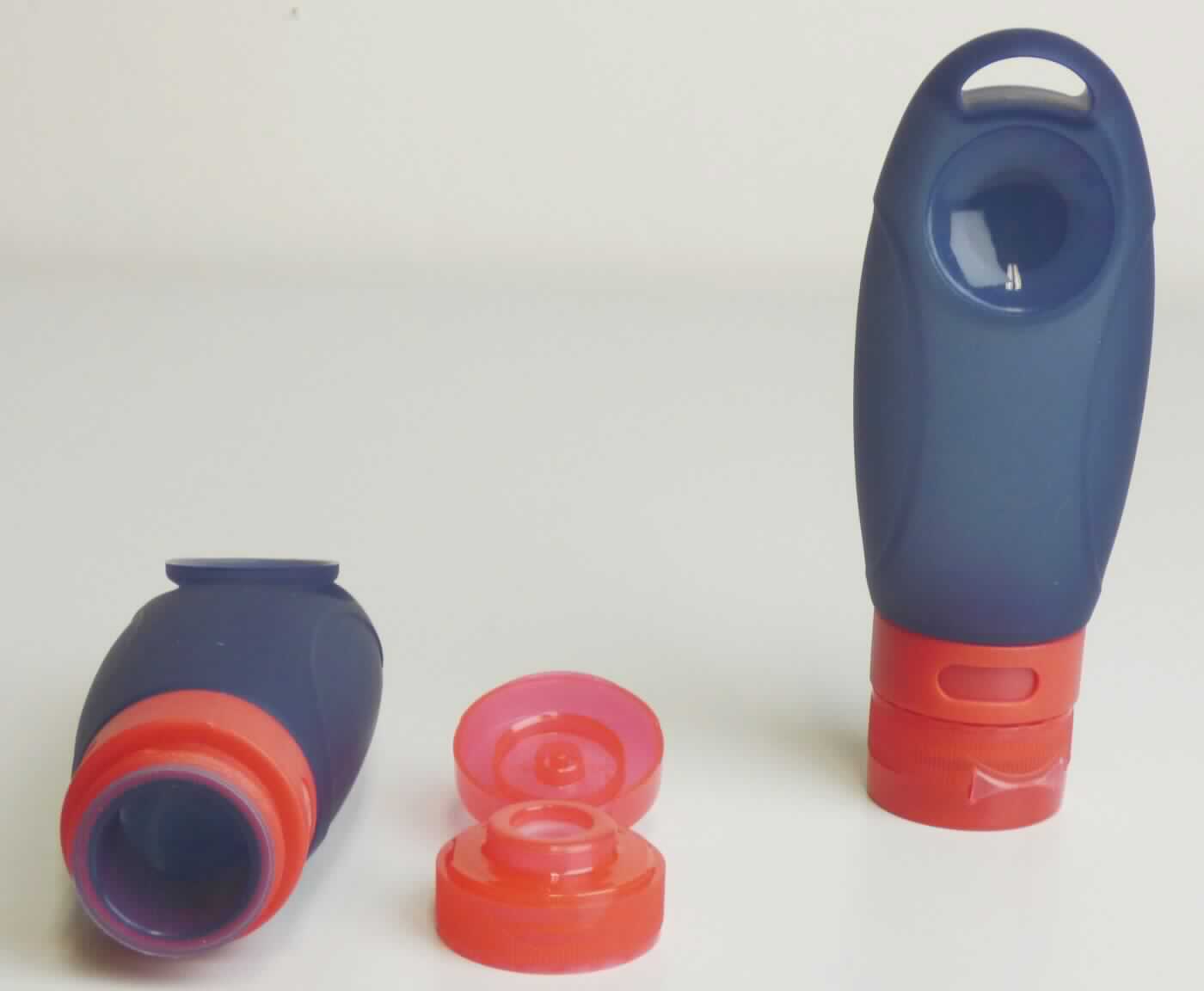 Es handelt sich um zwei leere, elastische Tuben aus Silikon, einem Kunststoff im Sinne der Anmerkung 1 zu Kapitel 39. Der ca.13,5 cm lange Tubenkörper mit einer Füllmenge von 89 ml ist sowohl mit einem Drehverschluss mit flachem Gewinde als auch mit einem Schraubverschluss mit Abdeckkappe versehen. Rückseitig ist der Tubenkörper im oberen Viertel mit einem Saugnapf versehen, mit dem er z.B. am Spiegel oder einer Badezimmerfliese befestigt werden kann. Am oberen Ende befindet sich eine nierenförmige Aussparung zum Aufhängen der Tuben z.B. an einem Haken.

Die in einem Polybeutel aufgmachten Tuben dienen üblicherweise dem Verpacken von z.B. Duschgel oder Shampoo auf Reisen und werden zolltariflich als "Transport- oder Verpackungsmittel aus Kunststoffen, andere als von den Codenummern 3923 1010 00 0 bis 3923 5090 00 0 erfasst" eingereiht.