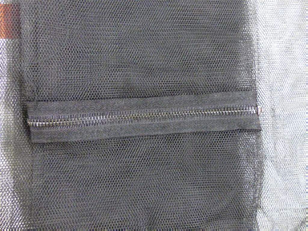 Konfektioniertes Netz, sog. Insektenschutzgitter, Foto siehe Anlage,
- rechteckig zugeschnitten, in den Abmessungen von laut Antrag ca. 170 cm x 140 cm,
- aus einfarbigen Kettengewirken aus laut Antrag Polyester (synthetische Chemiefasern);
  mit offenen, nicht verschiebbaren Zellen,
- im unteren Bereich mit einem eingenähten, ca. 42 cm langen Reißverschluss versehen,
- durch Zusammennähen konfektioniert,
- aufgrund des Verwendungszwecks (Fliegengitter) keine Gardine der Position 6303 und
  auch keine Ware zur Innenausstattung der Position 6304.

"Konfektioniertes Netz (Insektenschutz), aus synthetischen Spinnstoffen, aus Polyester"