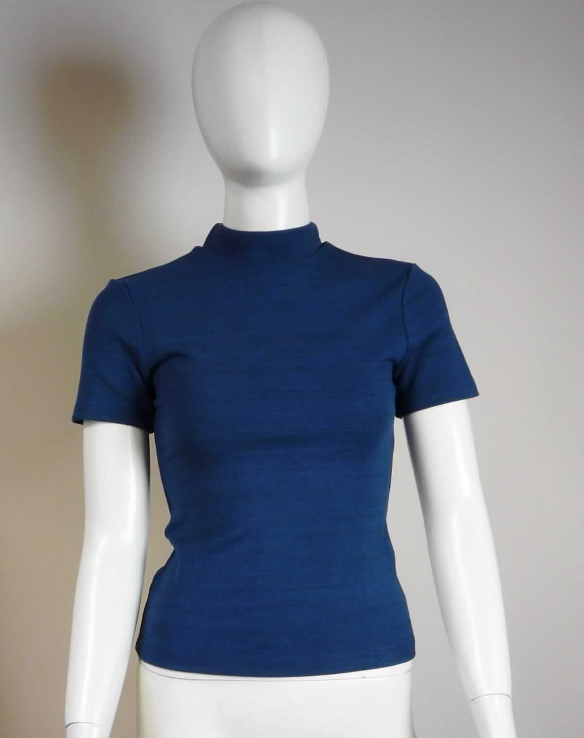 Unterziehpulli, sog. Strick T-Shirt, Art. RSAPO305, Größe S, Foto siehe Anlage,
- aus ca. 1,0 mm dicken (leichten), bedruckten Gewirken aus laut Antrag 93 % Viskose, 2% Polyester und 5 % 
  Elasthan (alles Chemiefasern); mit mehr als 12 Maschen je linearen Zentimeter in jeder Richtung (feinmaschig),
- über die Taille reichend (Rückenlänge: ca. 50 cm),
- mit einem enganliegenden, hohen Kragen (somit kein T-Shirt),
- ohne Öffnung und ohne Verschluss,
- mit kurzen, enganliegenden Ärmeln,
- enganliegend gearbeitet,
- am unteren Rand durch Umschlagen und Festnähen gesäumt,
- erfüllt die Merkmale zur Einreihung als Unterziehpulli, somit keine Ware der Unterposition 6110 3099.

"Pulloverähnliche Ware, Unterziehpulli, aus Gewirken, aus Chemiefasern"