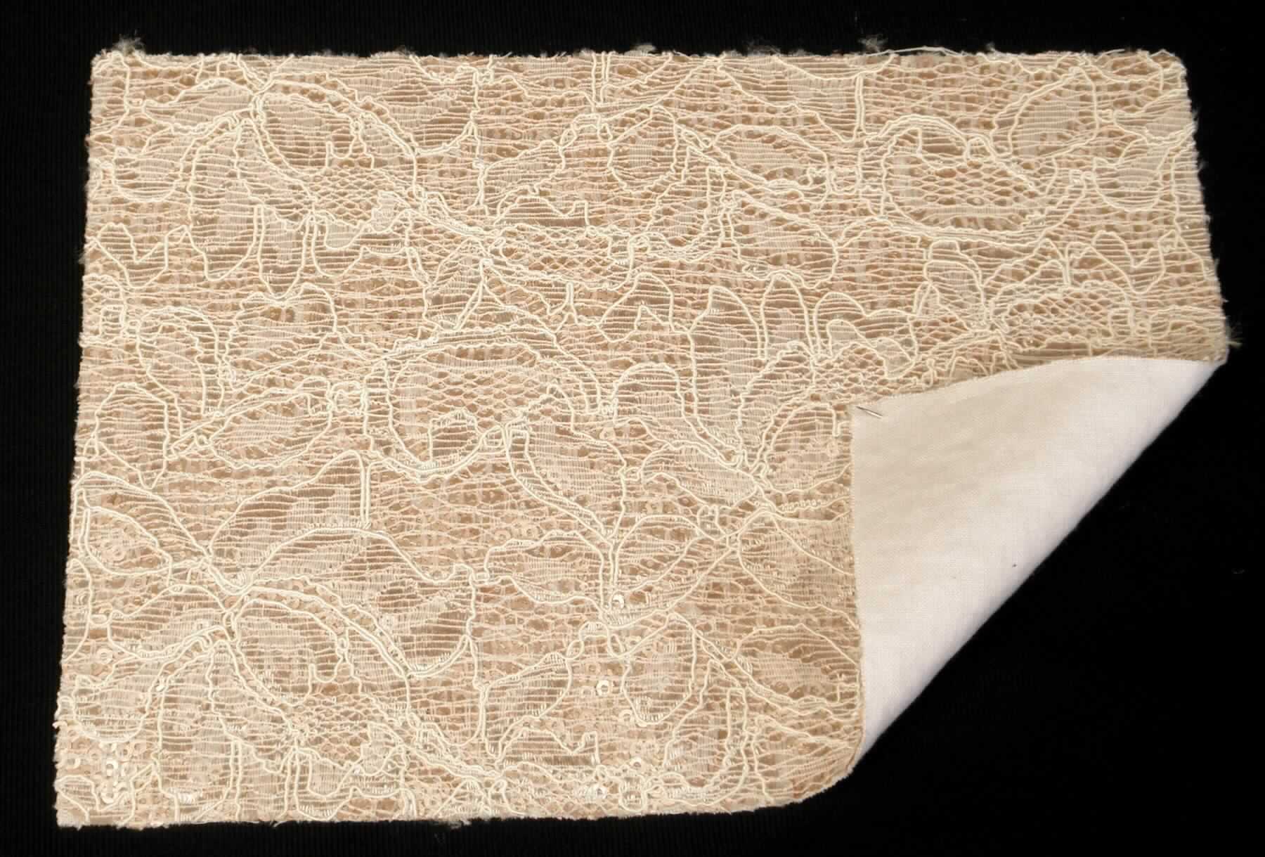 Textillaminat, Foto siehe Anlage,
- als Meterware, laut Antrag mit einer Breite von 130 cm,
- laut Untersuchungsergebnis:
-- aus drei mit ihrer ganzen Fläche aufeinander liegenden und so miteinander durch Kleben verbundenen Lagen: 
--- mit einer Oberlage (Schauseite): 
---- aus einem buntgewirkten Kettengewirke (sog. Raschelspitze), 
----- mit maschenbildenden Garnen aus synthetischen Chemiefasern (Polyamid),
----- mit dünnen, glänzenden Garnen aus synthetischen Chemiefasern (Polyamid),
----- mit dicken, glänzenden Garnen (Gimpe) aus künstlichen Chemiefasern (Viskose),
---- mit einem Gesamtanteil an:
----- synthetischen Chemiefasern von ca. 70 GHT,
----- künstlichen Chemiefasern von ca. 30 GHT,
---- keine Elastomergarne oder Kautschukfäden enthaltend,
---- kein Samt, Plüsch, Schlingengewirke oder Schlingengestricke,
---- stellt sich nicht als Gewirke im Sinne der Unterpositions-Anmerkung 1 zu Kapitel 60 dar,
--- mit einer Zwischenlage:
---- aus einer Applikationsstickerei mit einem Stickgrund aus Gewirken aus synthetischen Chemiefasern, 
---- mit aufgestickten Pailletten (Applikationen),
--- mit einer Unterlage:
---- aus einem einfarbigen Gewebe in Leinwandbindung, 
- im Hinblick auf die Verwendung verleiht das die Schauseite bildende Kettengewirke der Ware ihren wesentlichen
  Charakter.

"Kettengewirke, anderes als solche der Positionen 6001 bis 6004, aus synthetischen Chemiefasern, anderes
 als in der Unterposition 6005 35 genannte, aus verschiedenfarbigen Garnen"
