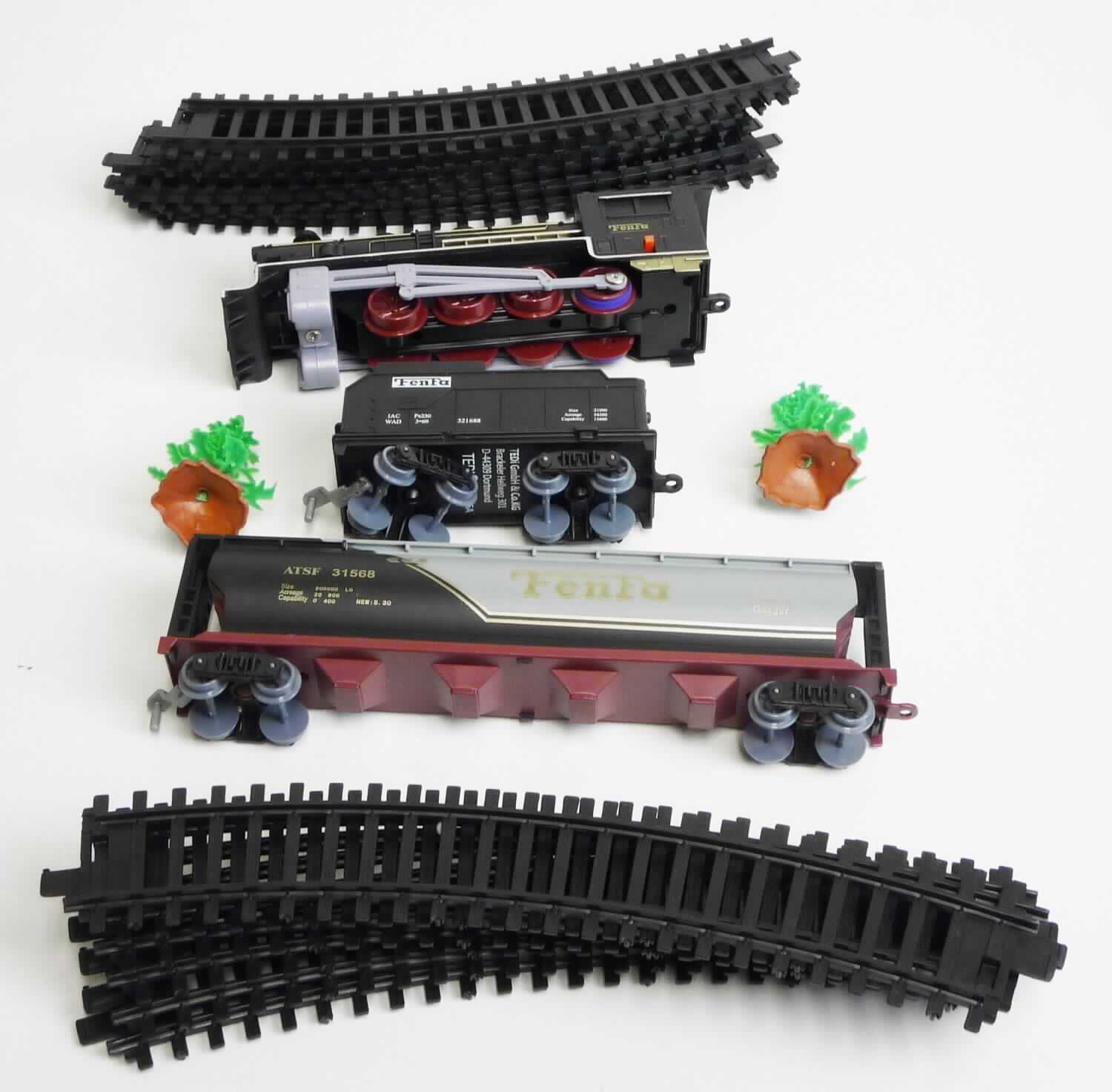 Spielzeug in Form eines sog. "Eisenbahnsets", bestehend aus
- 12 Schienenstücken aus Kunststoff in gebogener Form mit Koppelungen 
  an den Enden (lassen sich zu einem Ring mit einem Durchmesser von 
  ca. 101 cm zusammenlegen)
- einer batteriebetriebenen elektrischen Lok (Nachbildung einer Dampflok) aus Kunststoff
  mit Achsen aus unedlem Metall
-- in den Abmessungen von ca. 18 x 6,5 x 4,5 cm
-- an einer Seite des Führerhauses mit einem Ein-/Aus-Schalter
-- am hinteren Ende mit einer gezogen Öse als Anhängevorrichtung ausgestattet
- einem Waggon (Nachbildung eines Kesselwagens) aus Kunststoff mit
  Achsen aus unedlem Metall
-- in den Abmessungen von ca. 22 x 6 x 4,5 cm
-- am vorderen Ende mit einem Haken, am hinteren Ende mit einer gezogen Öse
   als Anhängevorrichtung ausgestattet
- einem ca. 6 x 3,5 x 3 cm großen Transportwaggon (Nachbildung eines Güterwagens) 
  aus Kunststoff, mit Achsen aus unedlem Metall
-- am vorderen Ende mit einem Haken, am hinteren Ende mit einer gezogen Öse
   als Anhängevorrichtung ausgestattet
- in Kombination mit zwei stilisierten Tannen aus Kunststoff, aus mehreren Elementen
  bestehend, die durch Stecken zusammengefügt sind (Waren der Position 6702; 
  keine Warenzusammenstellung, da die Waren nicht zur Befriedigung eines 
  gemeinsamen Bedarfs zusammengestellt sind).

Das Set ist gemeinsam in einem bunt bedruckten Pappkarton für den Einzelverkauf aufgemacht und dient der spielerischen Unterhaltung von Kindern. Die Kombination hat den wesentlichen Charakter von Spielzeug. 

Die Ware ist als "elektrische Eisenbahn, einschließlich Schienen, Signale und anderes Zubehör" einzureihen.