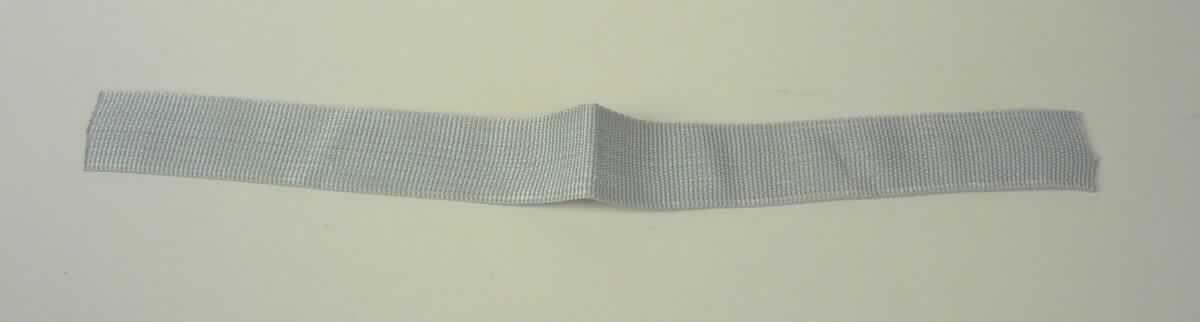 Band, sog. Gewebe aus Kunstfaser, Foto siehe Anlage,
- laut Antrag als Meterware auf Rollen, 
- mit einer Breite von ca. 2,5 cm (somit keine Ware der Position 5407),
- aus einem einfarbigen Gewebe aus laut Antrag synthetischen Chemiefasern,
- mit echten Webkanten an beiden Längsseiten, 
- kein Samt, Plüsch, Chenille- oder Schlingengewebe,
- keine Elastomergarne oder Kautschukfäden enthaltend.

"Band, keine Ware der Position 5807, anderes als in den Unterpositionen 5806 10 und 5806 20 genannte, 
 aus Chemiefasern, mit echten Webkanten"