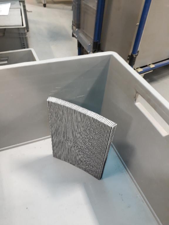 Filtertücher, Foto siehe Anlage,
- quaderförmig, in den Abmessungen (L x H x B) von laut Antrag 30 cm x 20 cm x 0,8 cm,
- laut Untersuchungsergebnis:
-- vierlagig, mit lamellenartig gefalteter Filterfläche:
--- mit einer Ober- und Unterlage aus einem Gewebe der Position 5903 aus synthetischen Filamenten
    mit laut Antrag Epoxidharz ummantelt, 
--- mit einer Zwischenlage aus einem Vliesstoff der Position 5603 aus synthetischen Chemiefasern,
--- mit einer weiteren Zwischenlage aus einem Vliesstoff aus Glasfasern,
--- durch Zusammenfügen konfektioniert,
- im Hinblick auf die Bedeutung in Bezug auf den Umfang (Menge) bestimmen die Spinnstoffe gegenüber
  den Glasfasern den Charakter der Ware,
- weist von der Konzeption her besondere Merkmale auf, die erkennen lassen, dass es sich um eine
  Ware des technischen Bedarfs aus Spinnstoffen handelt.
 
"Erzeugnisse des technischen Bedarfs, aus Spinnstoffen, aufgeführt in Anmerkung 8 zu diesem Kapitel,
 anderes als in den Unterpositionen 5911 10 bis 5911 32 genannte, Filtertuch zu ähnlichen technischen 
 Zwecken als der zum Pressen von Öl oder verwendeten Art"