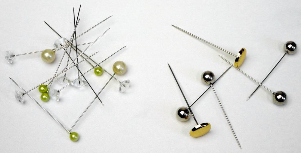Es handelt sich um Stecknadeln aus Stahl mit einem Kopf aus Kunststoff. Je nach Ausfertigung weisen die Nadeln unterschiedliche Längen, unterschiedliche Kopfformen und -farben auf und sind zu unterschiedlichen Mengen in Kunststoff-Boxen verpackt.
- Antragstellerangaben -

Abbildung siehe Anlage.

Der Charakter der aus verschiedenen Stoffen bestehenden Erzeugnisse wird aufgrund der Bedeutung für die Verwendung durch den Stahl bestimmt.

Derartige Erzeugnisse gehören als "Stecknadeln aus Stahl" zum TARIC-Code 7319 4000 00.