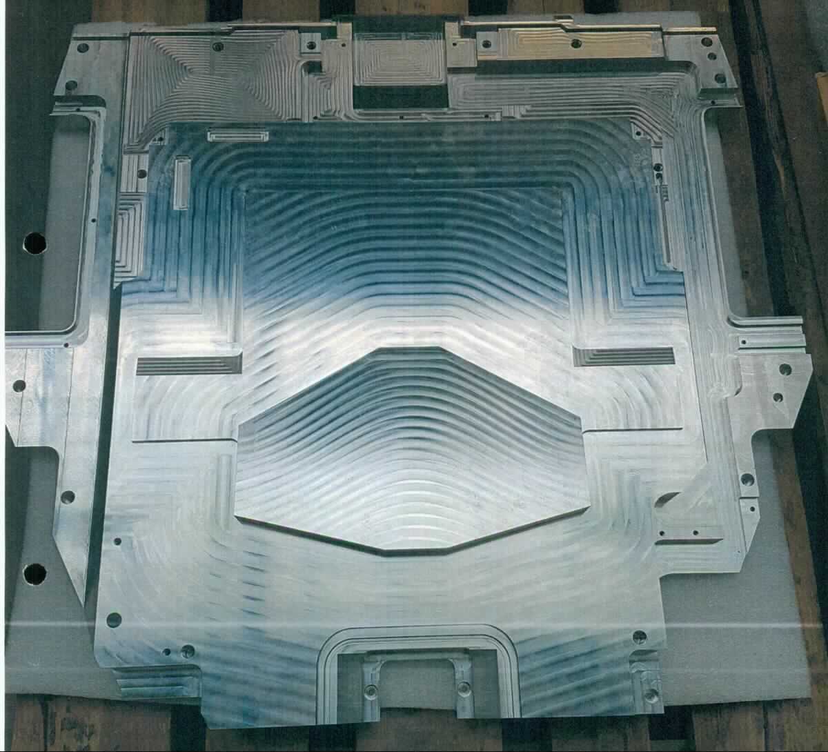 Sog. Illumo-Top-Plate mit Keenset
- in Form eines maßhaltig nach Werkzeichnung gefertigten, flächigen Einbauelements
  aus Aluminium-Guss, mit annähernd rechteckigem Grundriss, verschiedenen
  Aussparungen, Einpassstegen und Gewindebohrungen (Abbildung siehe Anlage),
- erkennbar als Abschlussdeckel zum Einbau in eine bei der Herstellung von Halb-
  leiterbauelementen verwendeten Lithographieanlage bestimmt.

"Teil, erkennbar ausschließlich für Apparate von der ausschließlich zur Herstellung von Halbleiterbauelementen verwendeten Art - sog. Illumo-Top-Plate mit Keenset für Lithographieanlage"