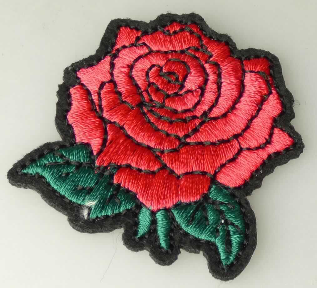 Applikationsstickerei, sog. Applikation "Rose", Art. 1450-32, Foto siehe Anlage,
- als Motiv, in Form einer Rose, in den Abmessungen: ca. 4 cm x 4,5 cm,
- auf einem Stickgrund aus Vliesstoff mit Stickgarnen bestickt, beide aus laut Antrag synthetischen Chemiefasern 
  (aus Polyester),
- auf der Rückseite mit klarsichtigem Kleber versehen,
- keine Ätzstickerei oder Stickerei mit herausgeschnittenem Grund,
- laut Antrag mit einem Wert von 58,98 EUR je kg Eigengewicht,
- ohne Hinweise auf Handarbeit.

"Stickerei als Motiv, andere als Ätzstickereien und Stickereien mit herausgeschnittenem Grund, aus Chemiefasern, 
 mit einem Wert von mehr als 17,50 EUR je kg Eigengewicht, nicht handgearbeitet"