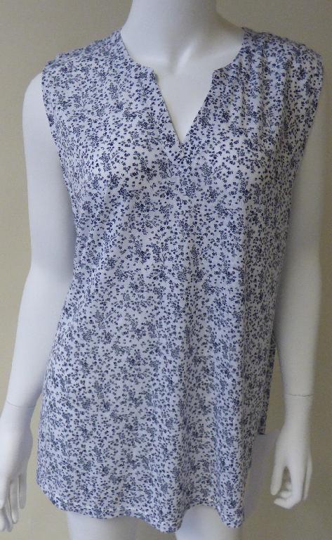 Modisches Unterhemd, sog. Damen Top mit floralem Muster, Größe 44, Foto siehe Anlage,
- auf einem Kleiderbügel hängend,
- aus ca. 0,4 mm dicken, bedruckten Gewirken aus laut Antrag 75 % Polyester und 25 % Viskose
  (beides Chemiefasern),
- über den Schritt reichend (Rückenlänge: ca. 72 cm),
- mit einem runden Halsausschnitt mit V-förmiger Einkerbung und einer von rechts auf links über-
  lappenden Randeinfassung; stellt sich nicht als sehr tief ausgeschnitten dar (daher keine Bluse),
- ohne Öffnung und ohne Verschluss,
- ärmellos, mit weiten Armausschnitten (somit kein T-Shirt),
- modisch gestaltet, wird unmittelbar auf der Haut getragen,
- am unteren, leicht bogenförmigen Rand und an den Armausschnitten durch Umschlagen und
  Festnähen gesäumt.

"Unterhemd, aus Gewirken, aus Chemiefasern"