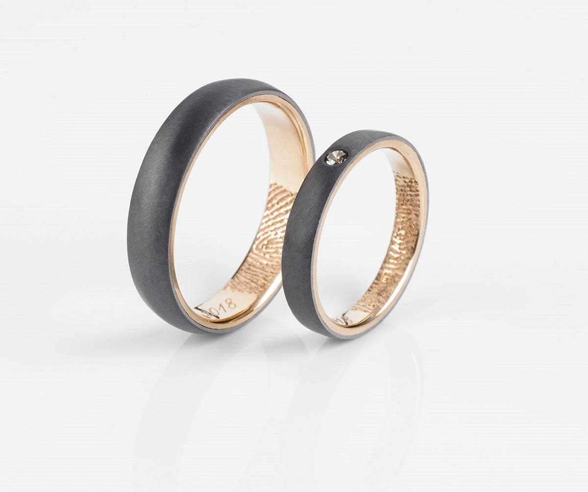 Es handelt sich um geschlossene Ringe aus Tantal (Fingerringe). Die Oberflächen können gelaserte Gravuren aufweisen.
Die Ringe weisen Goldlegierungen in den Feinheiten 585, 750 bzw. 900 in Gestalt einer sogenannten Goldschiene auf. Die Farben können zwischen Roségold, Weißgold, Rotgold oder Gelbgold variieren.

-Antragstellerangaben-
Abbildung siehe Anlage.

Eine Einreihung in die Position 7117 als Fantasieschmuck kommt nicht in Betracht, da die Ringe mit einer Goldlegierung versehen sind, die nicht lediglich als geringfügige Verzierung oder unwesentliche Zutat in dem Ring enthalten ist.
Derartige Erzeugnisse gehören als "Schmuckware aus Edelmetallen (andere als in der Unterposition 7113 1100 genannte), aus anderen Edelmetallen" zur Unterposition 7113 1900 der Kombinierten Nomenklatur.