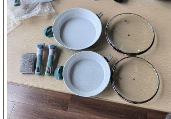 Es handelt sich um Warenzusammenstellungen, bestehend aus
- zwei Pfannen (Durchmesser: 24 cm und 28 cm), aus einem aus einer Aluminiumlegierung mit gewichtsmäßig vorherrschendem Aluminiumgehalt gefertigten, kreisrunden Pfannenkörper mit Boden aus Stahl und aus einem abnehmbaren Stielgriff aus Kunststoff und Stahl,
- zwei kreisrunden, passenden Deckeln aus Glas mit Griff aus Kunststoff und
- einem Schwamm mit Seifenkapsel im Inneren.
Die Erzeugnisse dienen dem Zubereiten von Speisen im Haushalt und sind gemeinsam in einem bedruckten Pappkarton für den Einzelverkauf aufgemacht.
- Antragstellerangaben -

Der Charakter der Warenzusammenstellung wird hinsichtlich der Bedeutung für die Verwendung durch die Pfannen bestimmt. Bei den aus verschiedenen Stoffen zusammengesetzten Pfannen bestimmen die unedlen Metalle im Hinblick auf die Bedeutung für die Verwendung und den Umfang den Charakter. Aluminium herrscht gegenüber Stahl gewichtsmäßig vor.

Abbildung siehe Anlage.

Derartige Erzeugnisse gehören als "andere Haushaltsartikel aus Aluminium, nicht gegossen" zur Codenummer 7615 1080 90 0 des Zolltarifs.