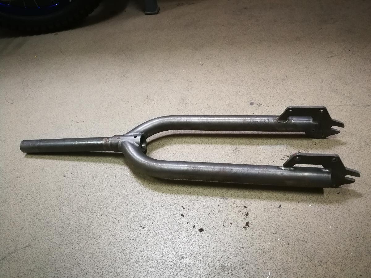 Vorderradgabel, Foto siehe Anlage,
- in der Bauweise einer geraden Starrgabel gefertigt,
- vollständig aus Stahl,
- mit einer Länge von ca. 660 mm und einer maximalen Breite von ca. 155 mm,
- mit einem Gabelschaftaußendurchmesser von ca. 28 mm,
- an den Gabelbeinen mit angeschweißtem Blech für die Bremssattelbefestigung,
- weder mit Farbe versehen, eloxiert, poliert und/oder lackiert (lt. Antrag roh),
- wird mittels des Steuersatzes drehbar im Steuerkopfrohr des Rahmens von Fahrrädern
  gelagert,
- dient u. a. der Aufnahme des Vorderrades und der Lenkung (durch drehbare Lagerung in den
  Lenkkopflagern) und der Verbindung zu den beweglichen Teilen des Steuersatzes, dem Vorbau
  und Lenker, 
- aufgrund der Konzeption (u. a. Form und Abmessungen) erkennbar hauptsächlich zur Verwendung
  in Fahrrädern des Kapitels 87 bestimmt.

"Teil für Fahrräder der Postionen 8711 und 8712, Vorderradgabel (Starrgabel aus Stahl), anderes
als in den TARIC-Codes 8714 9130 25 bis 8714 9130 72 genannte"