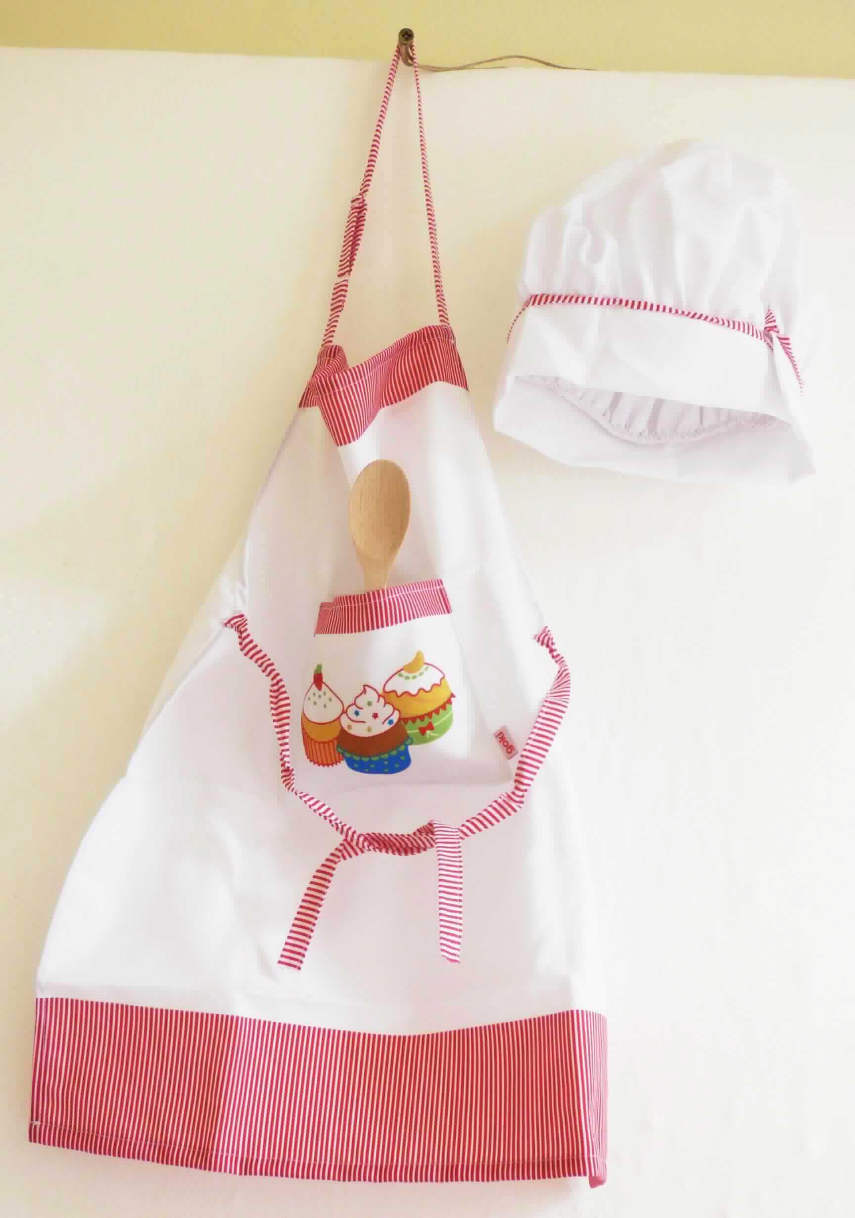 Kochset, Art. 51678, in Kindergröße, Fotos siehe Anlage,
- Warenzusammenstellung bestehend aus einer Schürze, einer Kochmütze und einem Kochlöffel,
- gemeinsam in einem Polybeutel mit bedrucktem Pappaufhänger für den Einzelverkauf aufgemacht und zur 
  Befriedigung eines speziellen Bedarfs zusammengestellt,
- Schürze:
-- in den Abmessungen: ca. 54 cm x 44 cm,
-- aus ca. 0,4 mm dicken, bedruckten Geweben aus laut Antrag 100 % Baumwolle,
-- als Latzschürze gearbeitet; den vorderen Teil des Körpers bedeckend, 
-- mit einem längenverstellbaren Nackenträger und Bindebändern in der Taille,
-- mit einer aufgesetzten, offenen Tasche, 
-- ohne Hinweise auf den Trägerkreis (unisex), 
-- an allen Rändern durch Umschlagen und Festnähen gesäumt,
-- aufgrund der Größe keine Einreihung in die Unterposition 6211 4210,
- Kopfbedeckung:
-- in den Abmessungen: ca. 29 cm x 26 cm,
-- aus bedruckten bzw. einfarbigen Gewebezuschnitten aus Spinnstoffen hergestellt,
-- in der Art einer Kochmütze,
-- oben geschlossen,
-- ohne Schirm,
-- am unteren Rand mit Klettverschluss ausgestattet,
- Kochlöffel:
-- in den Abmessungen: ca. 18 cm x bis zu ca. 3,6 cm,
-- aus Holz,
-- zur Verwendung in der Küche,
- im Hinblick auf den Umfang und die Verwendung ist die Schürze als charakterbestimmend anzusehen.

"Kleidung, andere als in den Positionen 6201 bis 6210 und in den Unterpositionen 6211 11 bis 6211 20
 genannte, aus Geweben, für Mädchen, aus Baumwolle, andere als in den Unterpositionen 6211 4210 bis
 6211 4242 genannte"
