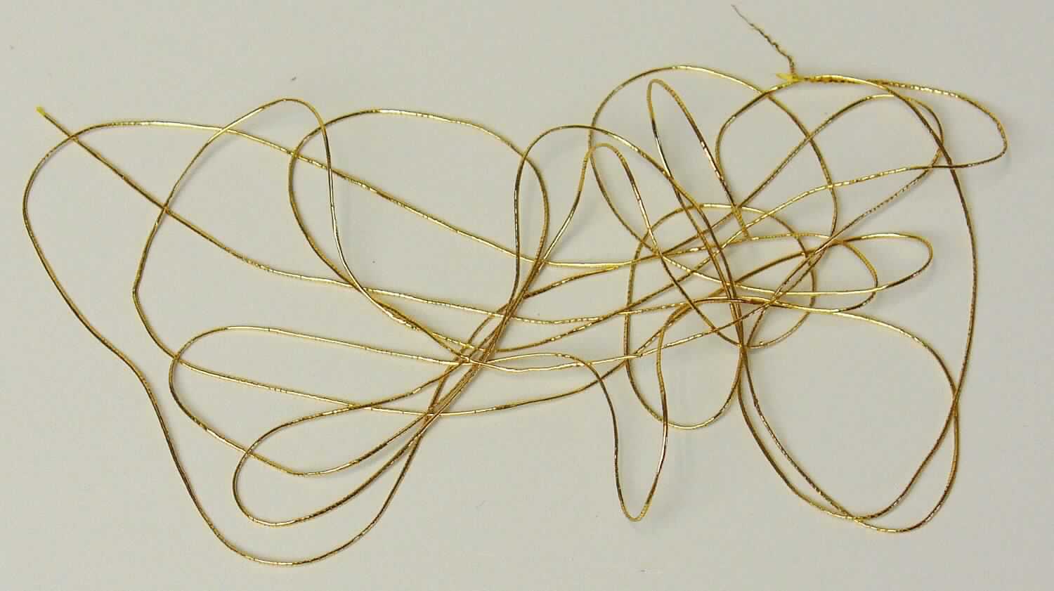 Metallisiertes Garn, sog. Goldfaden, Foto siehe Anlage,
- als Meterware,
- laut Untersuchungsergebnis:
-- bestehend aus einem Garn aus künstlichen und synthetischen Chemiefasern (laut Antrag Viskose und Polyester),
   welches kreuzweise mit zwei metallisierten Streifen aus synthetischer Spinnmasse (mit einer Breite von weniger  
   als 1 mm) umwickelt ist.

"Metallisiertes Garn, bestehend aus Garnen aus Spinnstoffen und mit Metall überzogenen Streifen der 
 Position 5404"
