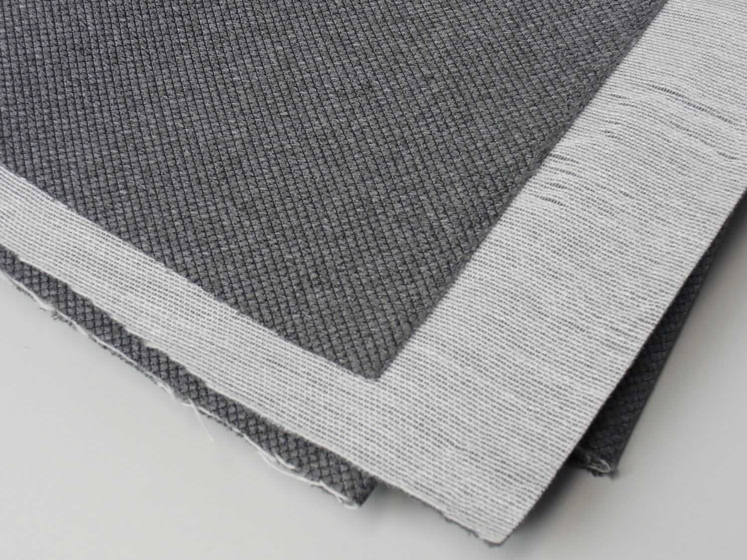 Textillaminat, Foto siehe Anlage,
- als Meterware; laut Antrag mit einer Breite von mehr als 30 cm,
- laut Untersuchungsergebnis:
-- aus zwei mit ihrer ganzen Fläche aufeinander liegenden und so miteinander durch Kleben verbundenen Lagen: 
--- mit einer Oberlage (Schauseite): 
---- aus einem buntgewirkten Kettengewirke,
---- aus synthetischen Chemiefasern (laut Antrag Polyester),
---- kein Samt, Plüsch, Schlingengewirke oder Schlingengestricke, somit keine Ware der Position 6001,
---- keine Elastomergarne oder Kautschukfäden enthaltend,
--- mit einer Unterlage:
---- aus einem einfarbigen Gewebe in Leinwandbindung,
- insbesondere im Hinblick auf die Bedeutung in Bezug auf die Verwendung verleiht das die Schauseite bildende 
  Kettengewirke der Ware ihren wesentlichen Charakter.

"Kettengewirke, anderes als solche der Positionen 6001 bis 6004, aus synthetischen Chemiefasern, anderes
 als in der Unterposition 6005 35 genannte, aus verschiedenfarbigen Garnen"