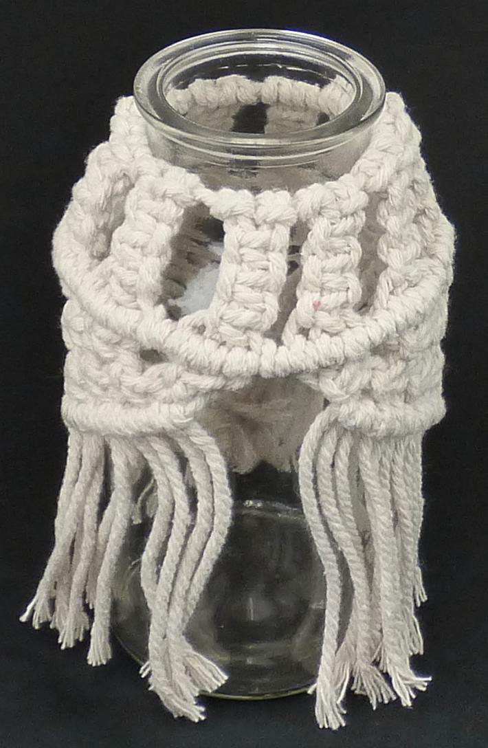 Glasware zur Innenausstattung, sog. Vase mit Makramee, Foto siehe Anlage,
- in Form eines zylinderförmigen, am Flaschenhals verengten, oben offenen Gefäßes aus
  klarsichtigem, laut Antrag gewöhnlichem, mechanisch gefertigtem Glas,
- mit einem in Makramee-Technik hergestellten Überzug aus Spinnstoff (laut Antrag Baumwolle),
- mit den Abmessungen: ca. 8 cm (Durchmesser) x 16 cm (Höhe),
- das Glas bestimmt im Hinblick auf den Umfang und seiner Bedeutung in Bezug auf die Verwendung
  als Vase den wesentlichen Charakter der Ware.

"Glasware zur Innenausstattung, aus gewöhnlichem Glas, nicht handgefertigt"