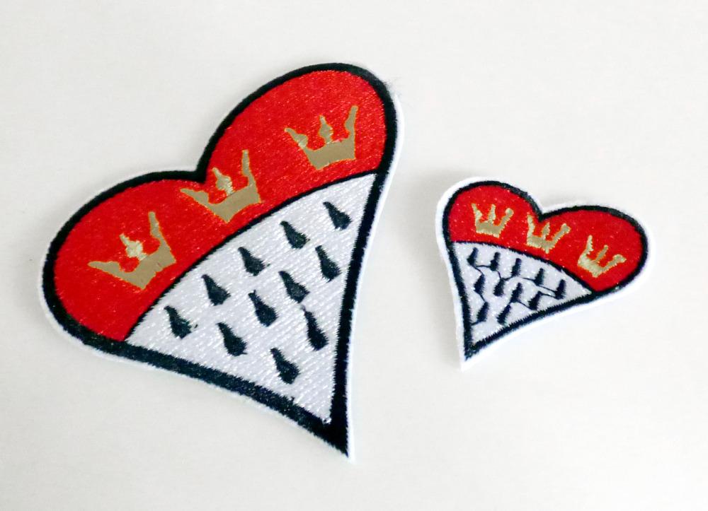 Stickerei als Motiv, sog. Bügelpatches - Tattoo zum Aufbügeln, Foto siehe Anlage,
- zwei Stück in einem Polybeutel verpackt,
- herzförmig in den Abmessungen von ca. 8,3 cm x 9 cm bzw. 4 cm x 4,5 cm,
- jeweils:
-- mit einem Stickgrund aus Vliesstoff aus Chemiefasern,
-- mit Stickgarnen bestickt,
-- keine Ätzstickerei oder Stickerei mit herausgeschnittenem Grund,
-- auf der Rückseite mit einem klarsichtigen Kunststoff versehen,
-- ohne Hinweise auf Handarbeit,
- laut Antrag mit einem Wert von mehr als 17,50 Euro je kg Eigengewicht.

"Stickerei als Motiv, andere als Ätzstickereien und Stickereien mit herausgeschnittenem Grund, aus
 Chemiefasern, mit einem Wert von mehr als 17,50 EUR je kg Eigengewicht, nicht handgearbeitet"