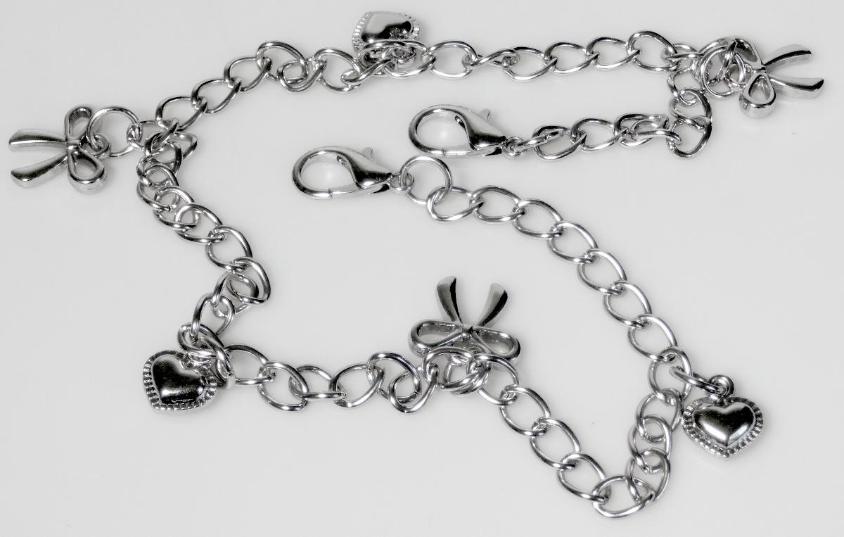 Es handelt sich um Fantasieschmuck zum Verzieren von Schnürsenkeln.
Die etwa 36 cm lange Gliederkette ist an beiden Enden jeweils mit einem Karabinerhaken ausgestattet.
An der Gliederkette befinden sich in einem Abstand von etwas 5,5 cm jeweils abwechselnd drei Anhänger in Form eines Herzens und drei Anhänger in Form einer Schleife.
Keine Handarbeit, nicht in Verbindung mit Glas.
Das Erzeugnis ist an einer bedruckten Pappkarte (10 cm x 15 cm) zum Verkauf aufgemacht.
- Antragstellerangaben -

Abbildung siehe Anlage.

Derartige Erzeugnisse sind als "Fantasieschmuck, aus unedlen Metallen, nicht versilbert, vergoldet oder platiniert (anderer als in Unterposition 7117 1100 genannter)" dem TARIC-Code 7117 1900 90 zuzuweisen.