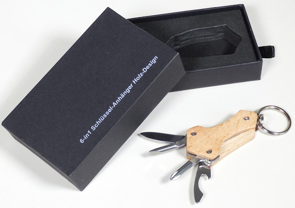 "6-in-1 Schlüsselanhänger"

aus verschiedenen Bestandteilen zusammengesetztes Erzeugnis, bestehend aus

- einem Klappmesser (Taschenmesser) mit schneidender Klinge aus unedlem Metall
  (charakterbestimmend), das gemeinsam unlösbar mit einem Kapselheber,
  einem Schlitz- und einem Kreuzschlitzschraubendreher, jeweils aus unedlem Metall,
  zwischen zwei Griffschalen aus Holz eingesetzt ist

- einem an den Griffschalen angebrachten Schlüsselring aus unedlem Metall

- in einer Pappschachtel mit einem Tiefzieheinsatz aus Kunststoff verpackt

Abbildung siehe Anlage.

Derartige Erzeugnisse gehören als "Messer mit schneidender, nicht feststehender Klinge aus unedlem Metall" zur Codenummer 8211 9300 00 0 des Zolltarifs.