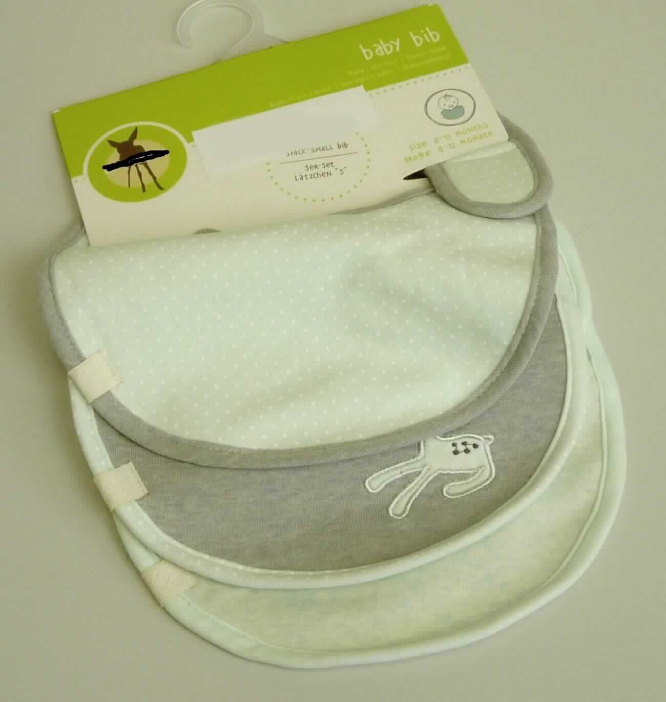 Lätzchen, Art. 1311007518,  Foto siehe Anlage,
- drei Stück (in unterschiedlichen Motiven) auf einer Pappkarte mit Aufhängevorrichtung aufgemacht und
  in einem Polybeutel verpackt,
- doppellagig gearbeitet; auf einer Seite aus ca. 0,8 mm dicken Gewirken aus laut Antrag 100 % Baumwolle,
  auf der anderen Seite aus 1,2 mm dicken, einseitig (Innenseite) mit Kunststoff (kein Zellkunststoff)
  überzogenen, einfarbigen Schlingengewirken aus laut Antrag 80 % Baumwolle und 20 % Polyester (synthetische
  Chemiefasern),
- annähernd rechteckig, mit abgerundeten Ecken, mit den Abmessungen: ca. 23 cm x 20 cm, 
- an den Rändern mit schmalen Gewirkestreifen eingefasst,
- im oberen Bereich mit einer Öffnung, die im Nacken mit einem Klettverschluss geschlossen werden kann; im
  geschlossenen Zustand mit einem Halsumfang von ca. 24 cm,
- ist für Kinder mit einer Körpergröße von bis zu 86 cm bestimmt.

"Bekleidungszubehör (Lätzchen), aus Gewirken, für Kleinkinder, aus Baumwolle"