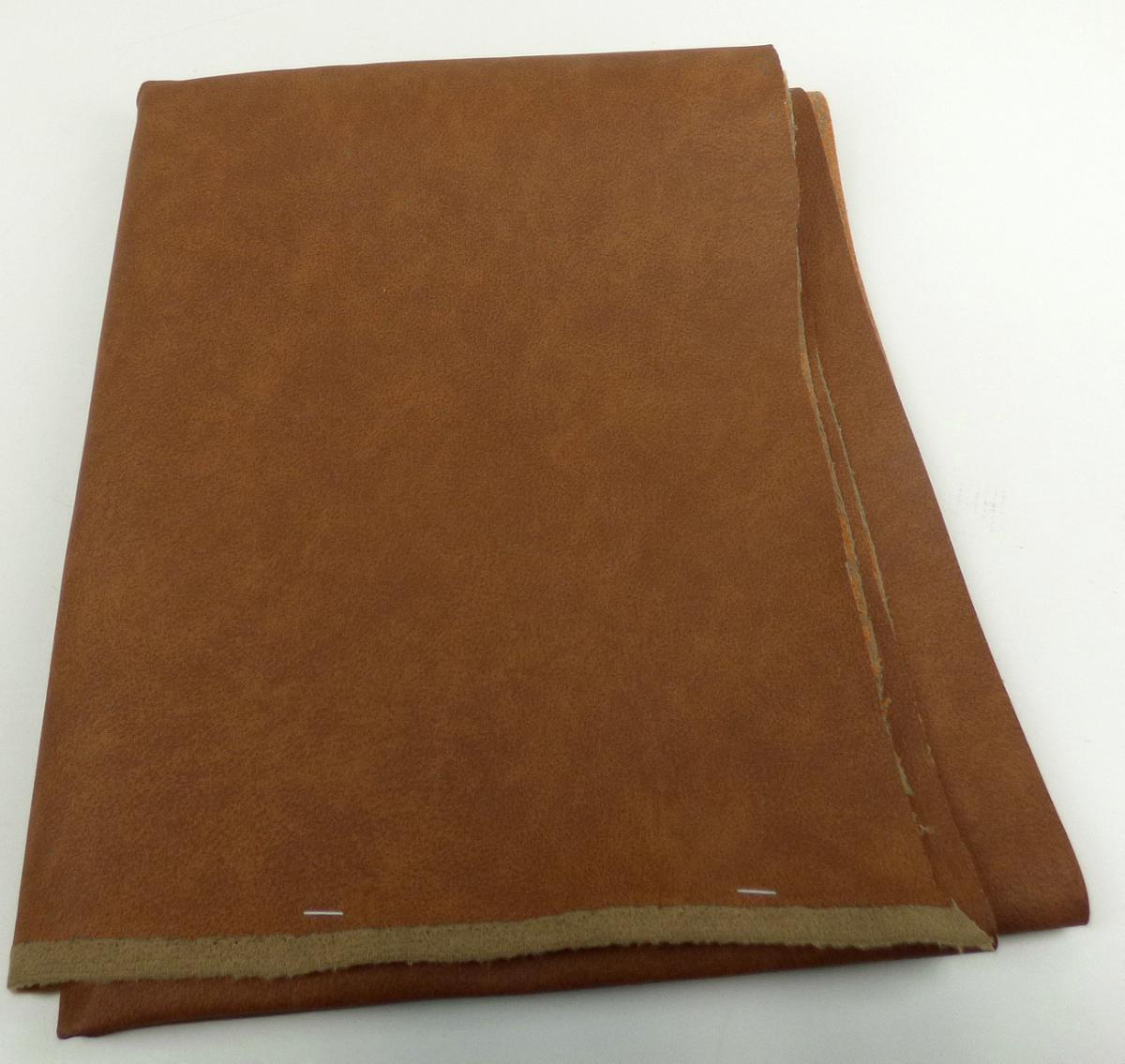 Mit Kunststoff überzogenes Gewirke, sog. Möbelbezugsstoff, Foto siehe Anlage,
- als Meterware, mit einer Breite von mehr als 30 cm,
- laut Untersuchungsergebnis:
-- aus einem Gewirke (= Gewebe im Sinne des Kapitels 59) aus synthetischen Chemiefasern, das auf
   der Außenseite mit bloßem Auge wahrnehmbar mit geprägtem Zellkunststoff (laut Antrag
   Polyvinylchlorid) überzogen ist; das Gewirke ist geraut, dicht und dicker (ca. 2/3 der Gesamtdicke) als
   der Zellkunststoff und dient damit nicht nur der Verstärkung,
-- auf der Rückseite mittels Klebstoff mit Lederfasern beflockt,
- von Hand bei einer Temperatur zwischen 15 und 30 °C auf einen Dorn von 7 mm Durchmesser
  aufrollbar, ohne rissig zu werden.
- insbesondere im Hinblick auf die Verwendung als Möbelbezugsstoff verleiht das die Schauseite
  bildende überzogene Gewirke der Ware ihren wesentlichen Charakter.

"Gewebe, mit Kunststoff (Polyvinylchlorid) überzogen, anderes als solche der Position 5902"