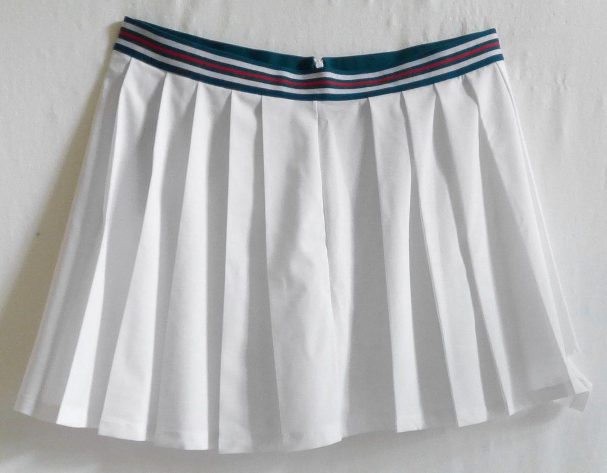 Rock, sog. FAW1109-10001 Fila New Skirt, Größe L, Foto siehe Anlage,
- aus ca. 0,4 mm dicken, einfarbigen Geweben aus laut Antrag 88 % Polyester und 12 % Elasthan
  (beides synthetische Chemiefasern),
- über den Schritt reichend (Seitenlänge: ca. 38 cm),
- in der Taille abschließend, mit einem ca. 3,5 cm breiten, angesetzten Bund aus einem elastischen,
  buntgewebten Band,
- seitlich mit einer ca. 15,5 cm langen Öffnung mit Reißverschluss,
- mit einem Schriftzug bedruckt,
- am unteren Rand durch Umschlagen und Festnähen gesäumt,
- kann ohne ein weiteres, den Unterkörper bedeckendes Kleidungsstück getragen werden.

"Rock, aus Geweben, für Frauen, aus synthetischen Chemiefasern, nicht nach dem Batik-Verfahren
 handbedruckt"