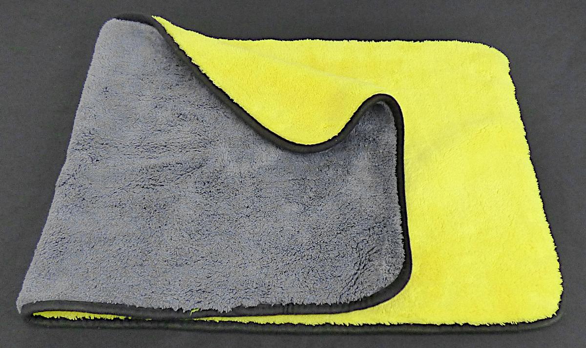 Reinigungstuch, sog. Trockentuch, Foto siehe Anlage,
- in einem Polybeutel verpackt,
- annähernd rechteckig, mit abgerundeten Ecken; in den Abmessungen (L x B) von ca. 
  82 cm x 39 cm,
- aus einem zweilagigen, durch Kleben miteinander verbundenen Textillaminat aus ver-
  schiedenen einfarbigen Plüschgewirken aus laut Antrag 80 % Polyester und 20 % Poly-
  amid (beides synthetische Chemiefasern),
- an allen Rändern mit einem Streifen aus Gewirken aus Spinnstoffen eingefasst (somit konfek-
  tioniert).

"Andere konfektionierte Ware (Reinigungstuch), aus Spinnstoffen, aus Gewirken"