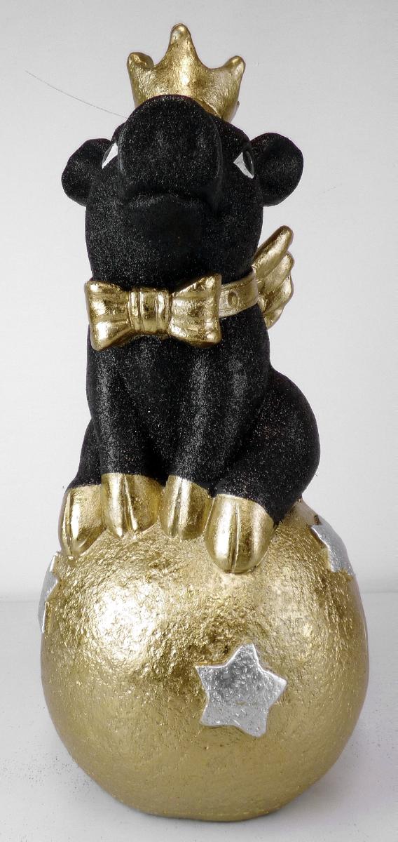 Angaben:
Glücksschwein auf Kugel; Material: 80 % Clay, 10 % Polyresin, 10 % Polyfiber.

Warenbeschaffenheit:
Zierfigur in Form eines schwarzen, glitzernden Schweinchens mit goldener Krone, goldener Schleife um den Hals und goldenen Flügeln, auf einer goldenen Kugel sitzend. Augenscheinlich besteht der Artikel aus mit Fasern vermischtem Zement.

Befund:
Waren aus Asbestzement, Cellulosezement oder dergleichen