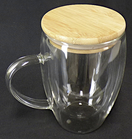 Glasware zur Verwendung bei Tisch, sog. Glastasse, Art.-Nr.: 8153766, Foto siehe Anlage,
- aus verschiedenen Stoffen zusammengesetzte Ware, bestehend aus:
- - einer Glastasse: 
- - - aus klarsichtigem, doppelwandigem, mechanisch gefertigtem Glas (laut Antrag
       Borosilikatglas) mit Henkel (damit kein Trinkglas),
- - - in den Abmessungen: ca. 8,5 cm (Durchmesser) x 12,5 cm (Höhe),
- - - mit einem Füllvermögen von ca. 350 ml,
- - einem abnehmbaren Deckel,
- - - aus Holz (laut Antrag Bambus),
- - - mit einer Dichtung aus Kunststoff, 
- - - in den Abmessungen: ca. 8,5 cm (Durchmesser) x 2 cm (Höhe),
- das Glas bestimmt nach dem Umfang und aufgrund seiner Bedeutung in Bezug auf
  die Verwendung den wesentlichen Charakter der zusammengesetzten Ware.

"Glasware zur Verwendung bei Tisch oder in der Küche, keine Glaskeramik, kein Trinkglas,
kein Bleikristall, aus Glas mit einem linearen Ausdehnungskoeffizienten von 5 x 10^-6 oder
weniger je Kelvin bei Temperaturen von 0 °C bis 300 °C"
