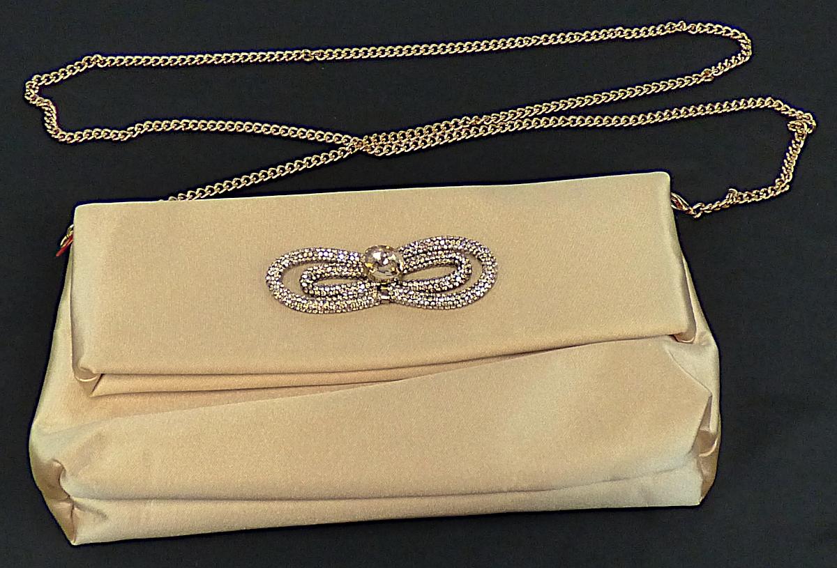 Handtasche, Foto siehe Anlage,
- mit einer Außenseite aus Spinnstoffen,
- an der Vorderseite mit einer schleifenähnlichen Verzierung aus Schmucksteinnachbildungen
  in der Art einer Schlangenkette,
- mit einem abnehmbaren Schultertrageriemen in Form einer Gliederkette aus unedlem Metall,
- an der Vorderseite mit einem eingesetzten Einsteckfach, das von der "Überschlagklappe"
  verdeckt wird,
- das Hauptfach ist mit einem im oberen Rand integrierten Magnetverschluss versehen;
  das obere Drittel der Handtasche wird in Art einer Überschlagklappe umgeschlagen und
  magnetisch fixiert,
- - gefüttert; ohne Inneneinteilung,
- mit den Abmessungen: ca. 25 cm (Breite) x 15 cm (Höhe) x 5 cm (Tiefe),
- laut Antrag nicht handgearbeitet,
- Handtasche, da aufgrund der Größe und des Gesamteindrucks in erster Linie dazu geeignet,
  kleinere, persönliche Gegenstände aufzunehmen.

"Handtasche, mit Außenseite aus Spinnstoffen, nicht handgearbeitet"