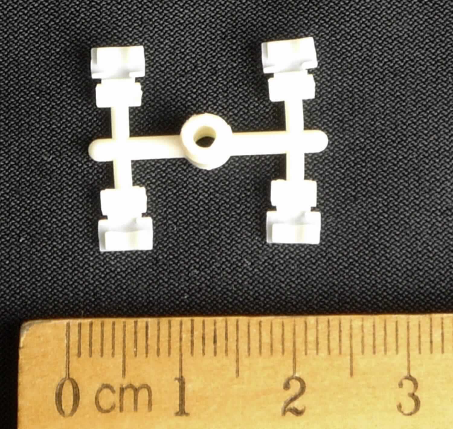 Hörgeräteteil, im Wesentlichen bestehend aus vier elastischen, flexiblen, mit Abstufungen bzw. Erhebungen versehenen, an einem H-Strang befestigten, weißlich-gelben Erzeugnissen aus Kunststoffen. Jedes der vier Erzeugnisse weist eine Länge von ca. 4,7 mm, eine Breite von ca. 2,7 mm und eine Stärke von ca. 0,5 mm auf, Außenmaße des gesamten Strangs: ca. 19,0 x 20,5 mm.
Äußere Form: siehe Abbildung in der Anlage.
Die Ware wird in einen Innenohr-Empfänger eines Hörgerätes (nicht Gegenstand dieser vZTA-Entscheidung) eingebaut. Sie befindet sich dort direkt unter der Platine (ebenfalls nicht Gegenstand dieser vZTA-Entscheidung). Durch die spezielle Form passt die Platine genau in das Hörgeräteteil, so dass ein Verrutschen dieser Platine vermieden und diese so vor Stößen und Erschütterungen (z. B. beim Herunterfallen des Hörgerätes) geschützt wird.

Die Ware wird als "Teil für ein Schwerhörigengerät" eingereiht.