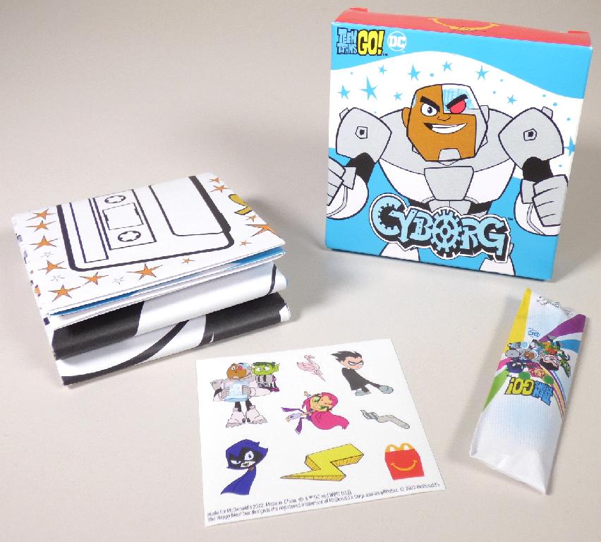 Es handelt sich um eine Zusammenstellung (Mc Donald`s - Teen Titans Go - 2022, Motiv: Cyborg), der nachfolgend beschriebenen Waren, die gemeinsam in einer mit Produktinformationen bedruckten Pappschachtel verpackt sind:

1. Ein Druckerzeugnis in Form eines rechteckigen Zuschnitts aus Papier (Abmessungen etwa 48,0 x 70,5 cm). Der Zuschnitt ist beidseitig im Wesentlichen mit kindgerechten Bilderrätseln (z. B. Unterschiede finden, Labyrinth) und einem Spiel (Drei gewinnt) bedruckt.

2. Zwei beidseitig angespitzte Buntstifte (Länge etwa 8,7 cm), die gemeinsam in einem Umschlag aus Papier verpackt sind.

3. Ein Stickerbogen (Abmessungen: 7,6 x 7,6 cm) (Ware mit geringem Wert).

Abbildung siehe Anlage.

Derartige Waren gehören als "andere Drucke, andere als solche der vorgenannten Codenummern" zur Codenummer 4911 99 00 00 0 des Zolltarifs, da es sich um eine Warenzusammenstellung in Aufmachung für den Einzelverkauf handelt, deren wesentlicher Charakter nach dem Wert und der Bedeutung für die Verwendung durch das unter 1. beschriebene Druckerzeugnis bestimmt wird.