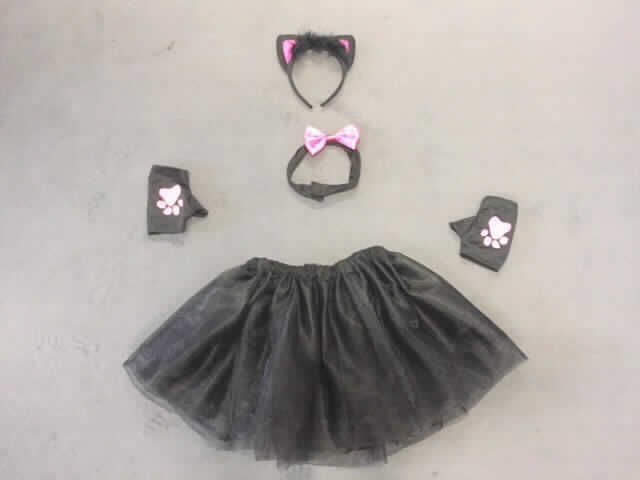 Karnevals-Set, sog. Damen-Katzen-Set, NAN 7145090, in Kindergröße, Foto siehe Anlage,
- Warenzusammenstellung, bestehend aus einem Rock, Handschuhen, einem Halsband und einem Haarreif,
- gemeinsam in einem Polybeutel für den Einzelverkauf aufgemacht und zur Befriedigung eines speziellen Bedarfs
  zusammengestellt,
- gehört als Maskenkostüm aus Spinnstoffen nicht zum Warenkreis der Position 9505,
- Rock:
-- mehrlagig gearbeitet (am Taillenbund dauerhaft zusammengenäht); mit drei Lagen jeweils aus 0,2 mm dicken,
   durchscheinenden Kettengewirken aus laut Antrag 100 % Polyester (synthetische Chemiefasern); an der
   äußeren und der Zwischenlage jeweils mit einem schmalen Streifen aus Geweben aus Polyester verziert, 
-- über den Schritt reichend (Länge: 34 cm), 
-- in der Taille abschließend, mit einem elastischen Taillenbund,
-- ohne Öffnung und ohne Verschluss,
-- am unteren Rand nur geschnitten,
- Handschuhe (Bekleidungszubehör):
-- aus ca. 0,4 mm dicken, einfarbigen Gewirken aus laut Antrag 100 % Polyester,
-- ohne ausgearbeitete Finger; mit ausgearbeitetem Daumen ohne Spitze,
-- auf dem Handrücken mit einer Katzenpfote bedruckt,
-- an den Rändern durch Umschlagen und Festnähen gesäumt,
- Halsband (andere konfektionierte Ware):
-- aus einem ca. 45 cm langen und ca. 3,5 cm breiten Zuschnitt aus zweilagig zusammengenähten, einfarbigen
   Gewirken aus laut Antrag 100 % Polyester (synthetische Chemiefasern), 
-- auf der Schauseite mittig mit einer aufgeklebten Schleife aus einfarbigen Geweben aus laut Antrag 100 %
   Polyester verziert,
-- an den Enden mit einem angenähten Klettverschluss ausgestattet,
-- durch Zusammennähen konfektioniert,
-- aufgrund des Verwendungszwecks als Halsschmuck (Halsband) kein Bekleidungszubehör,
-- kein Fantasieschmuck der Position 7117, da Waren aus Spinnstoffen vom Kapitel 71 ausgenommen sind,
- Haarreif (Karnevalsartikel):
-- bis zu ca. 1,8 cm breiter und ca. 13 cm langer, in ein Gewirke aus Spinnstoffen eingenähter Reif aus Kunststoff, 
-- am oberen Rand mit Federn umhüllt  und zwei angesetzten "Ohren" aus Spinnstoffen versehen,
-- wird ins Haar gesteckt und dient hauptsächlich dem Schmücken des Kopfes,
- im Hinblick auf den Umfang und den Gesamteindruck bestimmt der Rock den Charakter der Warenzusammen-
  stellung.

"Rock, aus Gewirken, für Mädchen, aus synthetischen Chemiefasern"