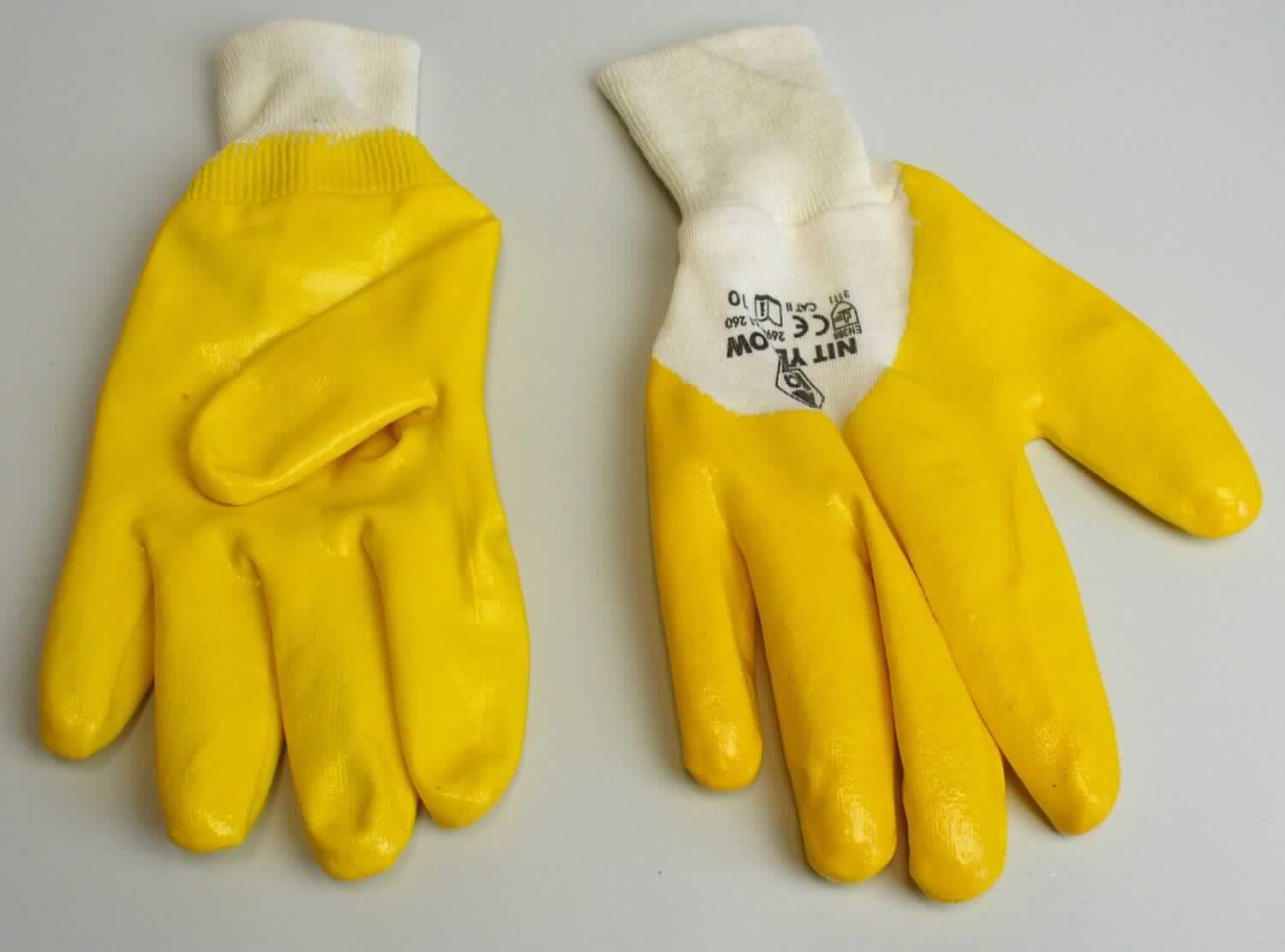 Fingerhandschuhe, sog. Montagehandschuh, Größe 10, Foto siehe Anlage,
- als Fünffingerhandschuhe gearbeitet,
- aus einfarbigen Gewirken aus laut Antrag Baumwolle,
- nachträglich mit Ausnahme des größten Teils der Stulpe und eines Teils des Handrückens einseitig (Außenseite) 
  im Tauchverfahren mit Kautschuk (laut Antrag: Nitril, keine Zellstruktur erkennbar) überzogen,
- im Bereich des Handrückens bedruckt,
- mit einer angesetzten, doppelt gearbeiteten Stulpe aus Gewirken.

"Fingerhandschuhe, aus Gewirken, mit Kautschuk überzogen"