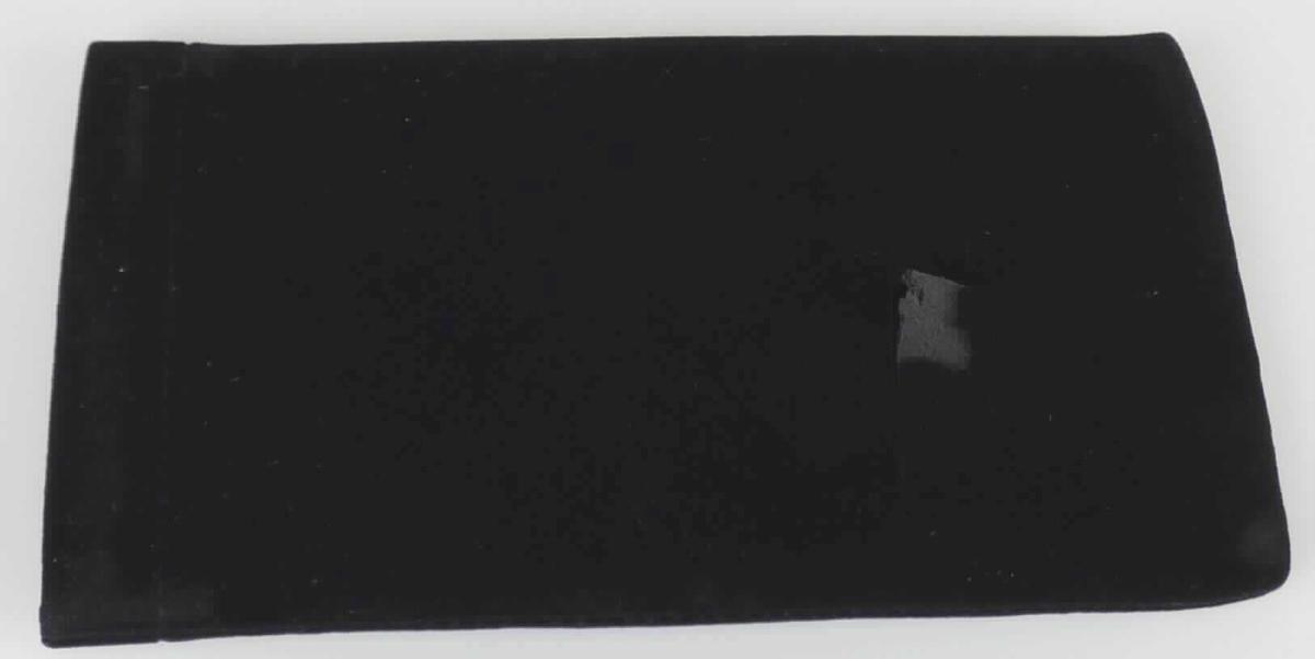 Brillenetui, Artikel 073 990 800 00 000, Foto siehe Anlage, 
- mit einer Außenseite aus Spinnstoff (Scherstaub auf einer Unterlage aus Zellkunststoff),
- an der Öffnung mit einem Schnappverschluss in Form zweier im Rand eingenähten Metallstreifen, 
- in den Abmessungen: ca. 17 cm (Höhe) x 9 cm (Breite), 
- in Form und Größe zur Aufnahme einer Brille gearbeitet, 
- ohne Hinweise auf Handarbeit.

"Brillenetui, Taschen- oder Handtaschenartikel, mit Außenseite aus Spinnstoffen, nicht handgearbeitet"