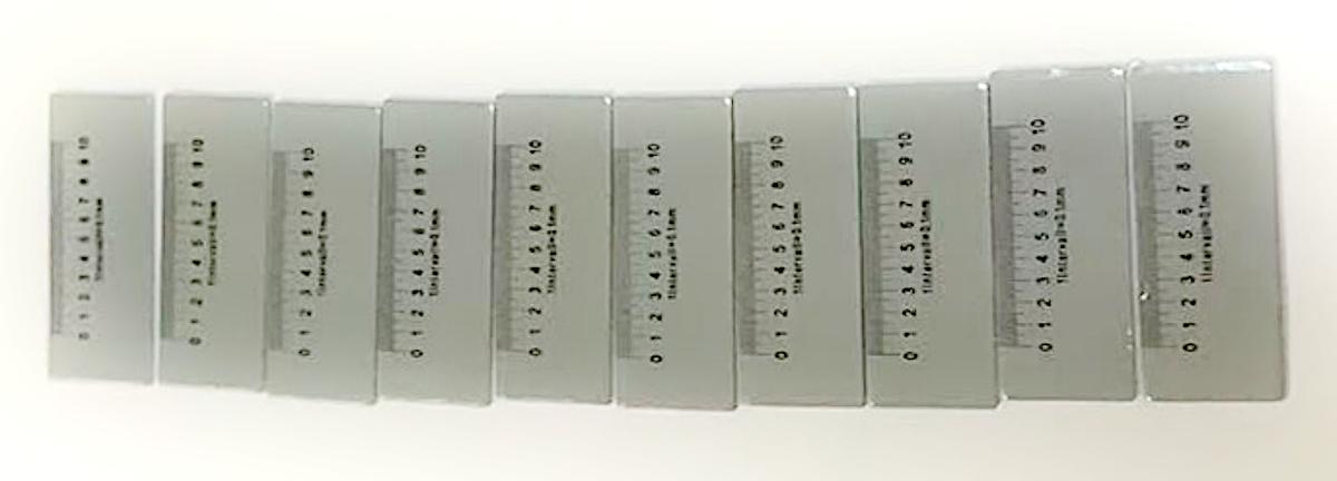 Sog. Messskala für Lupen, im Wesentlichen bestehend aus einem kartenförmigen Erzeugnis (15 x 6 mm) aus Kunststoff mit einer aufgedruckten Messskala von 0 bis 10 mm (in 0,1 mm-Schritten) auf der Oberseite und einem Klebestreifen auf der Unterseite (zur äußeren Form siehe Abbildung in der Anlage).

Die Ware wird in den Bereich des Standfußes einer Standlupe mit achtfacher Vergrößerung (nicht Gegenstand dieser vZTA-Entscheidung) geklebt und dient dem Messen von Längen im unteren Millimeterbereich.

Eine Einreihung der Messskala in die Pos. 9017 kommt nicht infrage, da diese wegen der geringen Größe zur Messdurchführung nicht in der Hand gehalten werden kann.

Die Ware wird als "Gerät zum Messen oder Prüfen geometrischer Größen (Länge), in Kapitel 90 anderweit weder genannt noch inbegriffen, anderes als in den Unterpositionen (KN) 9031 1000 bis 9031 4990 genannt" eingereiht.