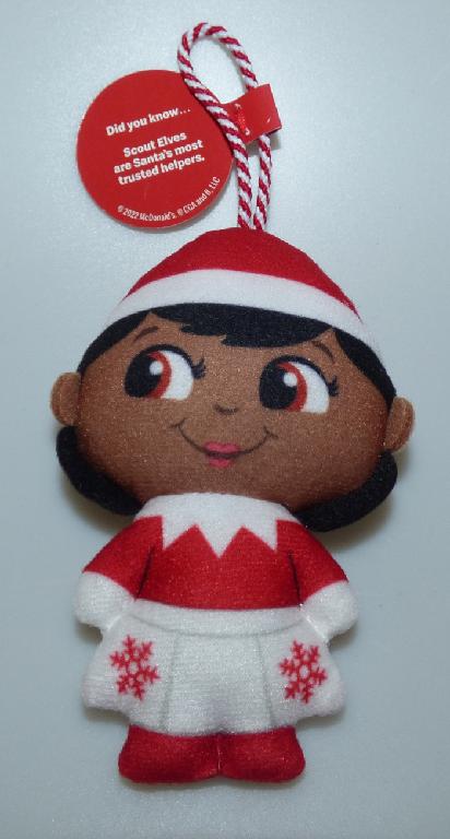 Bei der durch ein Warenmuster veranschaulichten und als "Mc Donald´s - The Elf on the Shelf - 2022", Motiv: Scout Brown Eyed Girl" bezeichneten Ware handelt es sich um eine Puppe
- einen Menschen (Mädchen) darstellend,
- ca. 10,5 cm groß,
- aus Spinnstoff gefertigt und mit weichem Material befüllt,
- mit durch Nähte abgeteilten Armen und angedeuteten Beinen, die materialbedingt
  beweglich sind,
- mit einem aufgedruckten Gesicht und braunen Haaren,
- durch entsprechende farbliche Darstellung dem Anschein nach mit einem Oberteil,
   einem Rock, Schuhen und einer Mütze bekleidet,
- am oberen Ende mit einer Aufhängeschlaufe aus Spinnstoff versehen,
- dient der spielerischen Unterhaltung,
- in einer bunt bedruckten Pappschachtel verpackt.

Derartige Erzeugnisse werden zolltarifrechtlich als "Puppe, die Nachbildung eines Menschen darstellend, keine handgearbeitete Puppe in für das Ursprungsland charakteristischer Volkstracht" eingereiht.