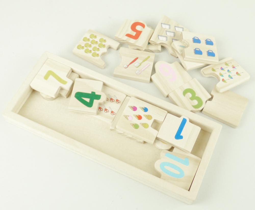 Spielzeug in Form eines Puzzles, "Zahlenboard", bestehend aus
-10 je zweiteiligen Puzzles aus Holz
- jeweils ca. 8 x 4,2 x 0,7 cm groß
- mit einem Puzzleteil, auf dem eine Zahl von 1 bis 9 abgebildet ist, das andere Puzzleteil
  mit der entsprechenden Anzahl von Gegenständen wie z.B. Enten, Regenschirmen oder
 Tassen bedruckt
- es lassen sich nur die entsprechenden Puzzleteile anlegen, bei denen sich Zahl und Anzahl
  entsprechen
- ohne Hinweis auf Fertigung in Handarbeit
- in einem passgenauen Holzrahmen für den Einzelverkauf aufgemacht.

Die Ware wird zolltarifrechtlich als "Puzzle, aus Holz, nicht handgearbeitet" eingereiht.