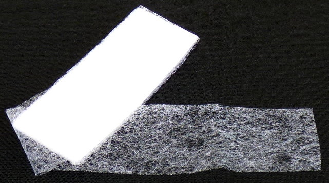Vliesstoff, sog. Saumband, Foto siehe Anlage,
- als Meterware; laut Antrag mit einer Länge von 10 m und einer Breite von 2 cm,
- aus synthetischen Filamenten (laut Antrag Polyamid; keine aromatischen Polyamide),
- mit Bindemittel verfestigt,
- kein melt blown,
- weder bestrichen noch überzogen,
- laut Untersuchungsergebnis mit einem Quadratmetergewicht von ca. 20 g.

"Vliesstoff, aus synthetischen Filamenten, mit einem Quadratmetergewicht von weniger als 25 g,
 weder bestrichen noch überzogen, anderer als in der Unterposition 5603 1190 10 genannte"