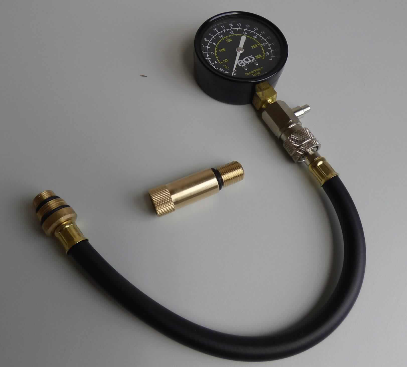 Sog. Kompressionstester, in Form einer Warenzusammenstellung in Aufmachung für den Einzelverkauf im Wesentlichen bestehend aus
- einem Tester,
- einem Adapter aus unedlem Metall sowie
- einer Bedienungsanleitung
in einem bedruckten Pappkarton als gemeinsame Verkaufsverpackung.
Der Tester als kombinierte Maschine besteht im Wesentlichen aus einem zylinderförmigen Gehäuse (Durchmesser 70 mm) mit einem Rohrfedermesswerk, einer analogen Messwertskala (3 bis 20 bar; 50 bis 300 psi), einem Zeiger, einem Ventil sowie einem 30 cm langen Prüfschlauch mit einem Schraubanschluss.
Das Manometer (kennzeichnende Haupttätigkeit) wird zum Messen des Druckes an Verbrennungsmotoren verwendet.

Zur äußeren Form siehe Abbildung in der Anlage.

Die Ware wird als "Gerät zum Messen oder Überwachen des Druckes von Flüssigkeiten oder Gasen, ausgenommen Instrumente, Apparate und Geräte der Position 9014, 9015, 9028 oder 9032, als Manometer mit Metallfedermesswerk (Rohrfeder)" eingereiht.
