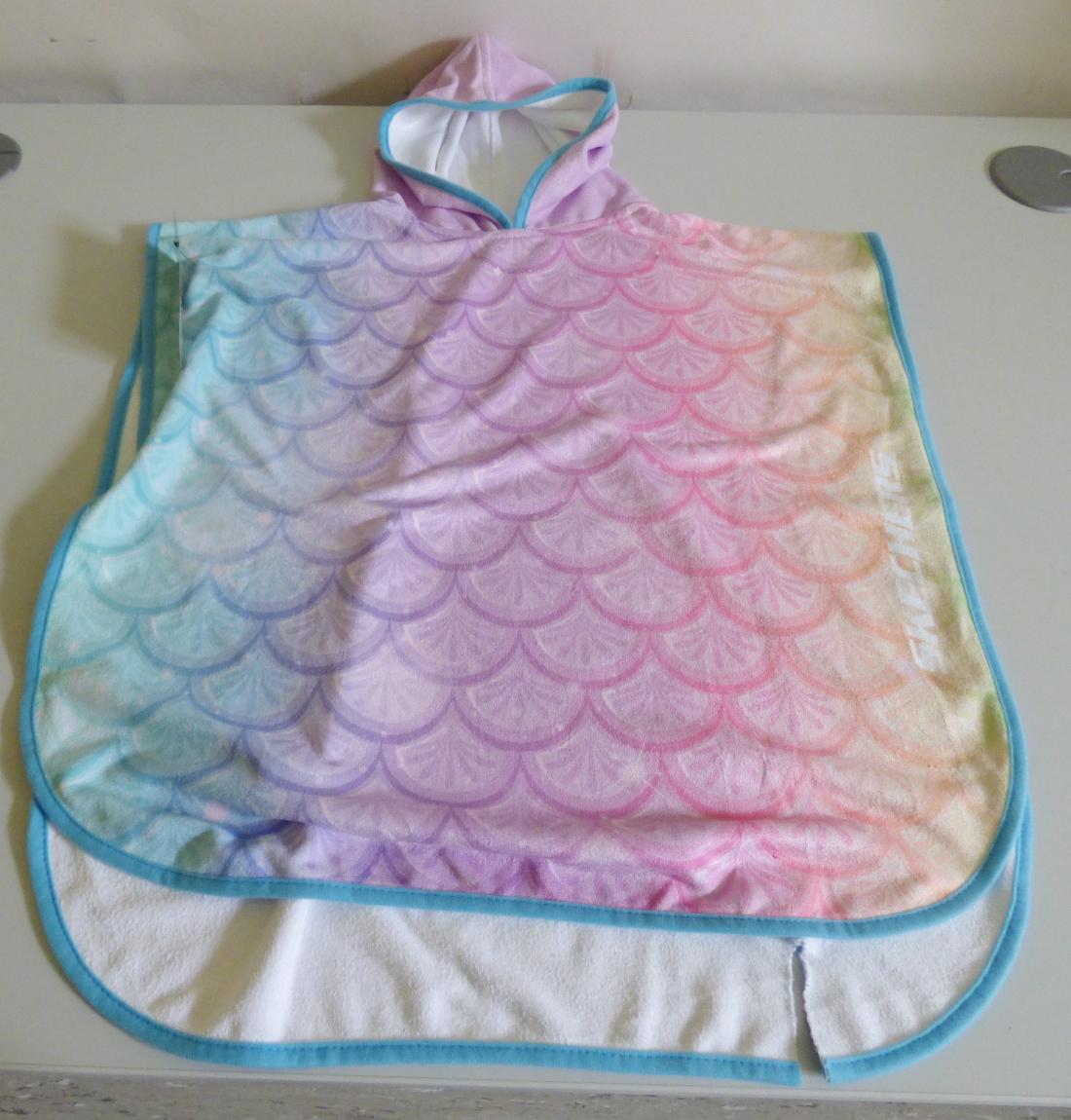 Badeüberwurf, sog. Kids Badeponcho, in Einheitsgröße für Kinder, Foto siehe Anlage,
- aus ca. 1,3 mm dicken, bedruckten Schlingengewirken nach Art der Frottiergewirke aus laut Antrag
  80 % Nylon und 20 % Polyester (beides synthetische Chemiefasern),
- flachliegend mit den Abmessungen von ca. 64 cm (Länge) x 60 cm (Breite),
- wird in der Art eines Überwurfs über den Schultern getragen; seitlich offen, die Schultern und Teile
  der Arme bedeckend,
- mit angenähter Kapuze,
- ohne Öffnung oder Verschluss,
- ohne Hinweise auf den Trägerkreis (unisex),
- an allen Rändern mit schmalen Randeinfassungen aus Gewirken,
- ist nicht nur für Kleinkinder mit einer Körpergröße von bis zu 86 cm bestimmt,
- aufgrund der verwendeten Flächenerzeugnisse keine Ware des Kapitels 62.

"Den Bademänteln ähnliche Ware (Badeüberwurf), aus Gewirken, für Mädchen, aus Chemiefasern"