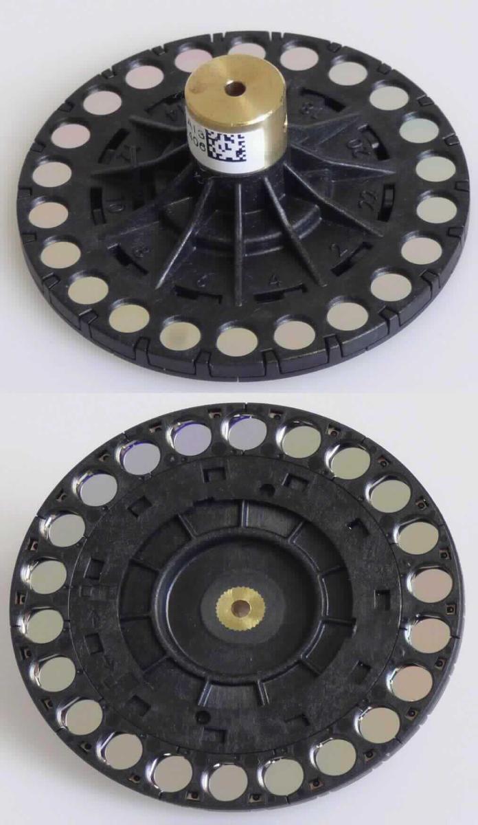 So genannter Farbfilter, im Wesentlichen bestehend aus einem Kunststoffrad (Durchmesser: 46,2 mm) mit darin eingelassenen 22 Filterscheiben (Durchmesser: 4,3 mm) und Vorrichtung zur Montage der Ware in einem Farbmessgerät (nicht Gegenstand dieser vZTA-Entscheidung).
Bei den Filterelementen handelt sich um Glasscheiben mit einer Interferenzbeschichtung, die die Filterwirkung erzielt.
Zur Messung wird das Rad im Gerät gedreht und von einer Lichtquelle durchschienen um das Prüfmuster (beides ebenfalls nicht Gegenstand dieser vZTA-Entscheidung) in einer durch den jeweiligen Filter definierten Wellenlänge zu beleuchten.
Das Erzeugnis wird als "optisches Element, aus Stoffen aller Art, für Instrumente und Geräte, gefasst, nicht aus nicht optisch bearbeiteten Glas, Filter" eingereiht.