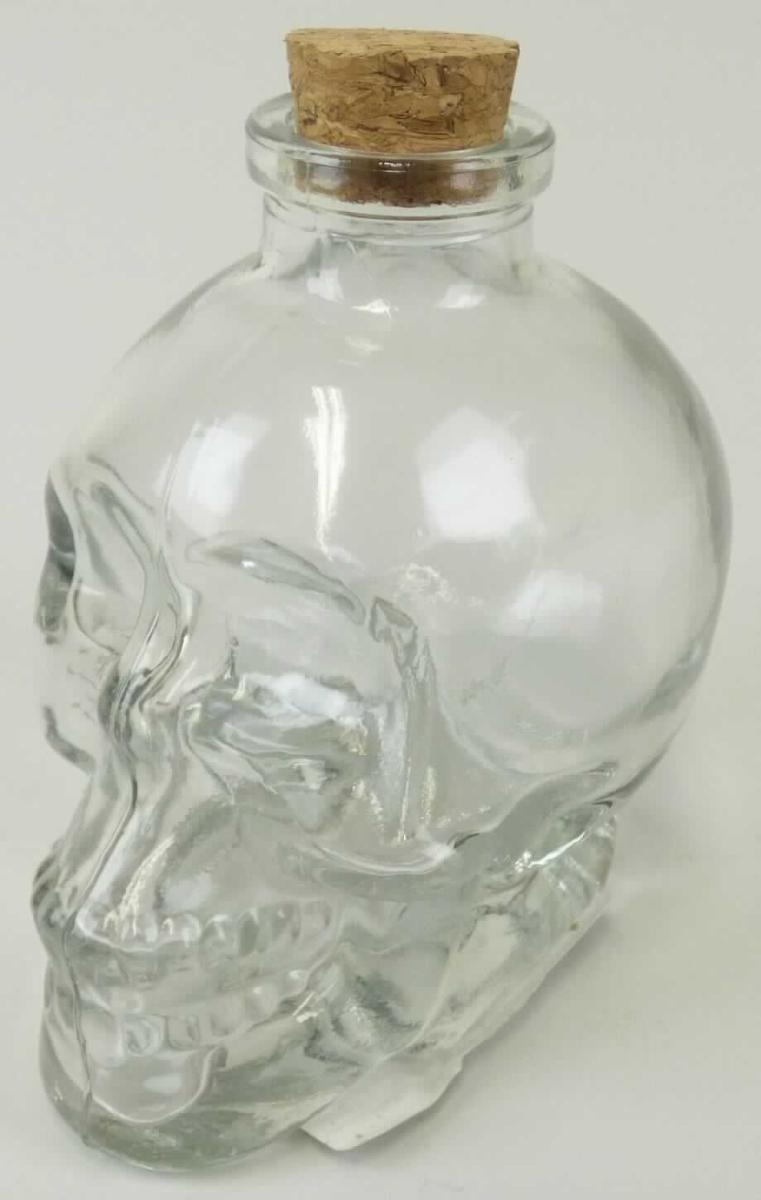 Glasware zur Verwendung bei Tisch und in der Küche, sog. Glasflasche Totenkopf mit Korkverschluss, 
Foto siehe Anlage, 
- klarsichtiges Gefäß in Form eines Totenkopfs, 
- aus gewöhnlichem, mechanisch gefertigtem Glas (Pressnaht erkennbar), 
- am unteren Ende abgeflacht gearbeitet,
- am oberen Ende mit einem kurzen Flaschenhals; oben offen,
- mit einem locker in die Öffnung eingesetzten Stopfen aus Kork,
- mit einer Höhe von ca. 9,5 cm,
- an der Öffnung mit einem Durchmesser von ca. 2 cm,
- mit einem Nennvolumen von laut Antrag 180 ml, 
- leer, kann mit einer beliebigen Flüssigkeit befüllt werden,
- aufgrund ihrer objektiven Merkmale (die spezifische Form der Ware, der Stopfen aus Kork ist nur locker
  eingesteckt und weist keine Dichtung auf) ist die Ware üblicherweise nicht dazu bestimmt, gewerblich
  für die Beförderung oder Verpackung von Waren im Sinne der Position 7010 verwendet zu werden.

"Glasware zur Verwendung bei Tisch oder in der Küche, nicht aus Glaskeramik, Bleikristall, Borosilikatglas 
 oder vorgespanntem Glas, mechanisch gefertigt (mechanische Glasentnahme)"