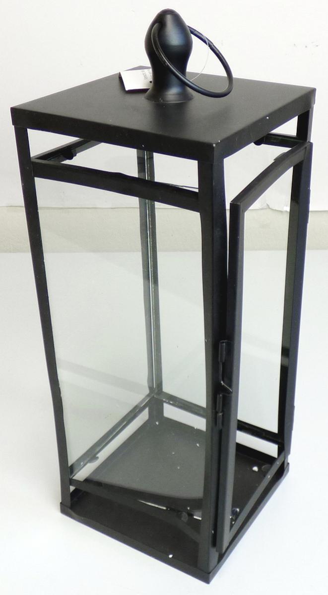 Bei der sog. Metall-Laterne, NAN: 8004973 handelt es sich um eine viereckige, ca. 14 cm x 14 cm x 39 cm (L x B x H) große Laterne, bestehend aus einem Metallgestell (lt. Antrag Eisen) mit einer Grundplatte und mit eingesetzten Seitenscheiben aus Glas, sowie einem flachen Metalldach mit Tragegriff.
Eine Seite fungiert als Tür zum Einstellen eines Teelichtes oder einer Kerze.
Im oberen Bereich sind Belüftungslöcher zur Abführung von Wärme und Rauch vorhanden.

Hinweise auf eine Handarbeit liegen nicht vor.

Die Ware ist als "nicht elektrischer Beleuchtungskörper, anderweit weder genannt noch inbegriffen, nicht handgearbeitet" einzureihen.