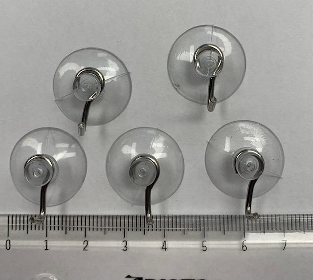 Es handelt sich um Haken aus unedlem Metall, die an einem Ende annähernd U-förmig und an dem anderen Ende zu einer offenen Öse gebogen sind. Die Öse umschließt den "Kopf" eines Saugnapfs aus transparentem Kunststoff. 
Die Erzeugnisse werden an glatten Oberflächen angebracht und dienen dem Aufhängen von verschiedenen Gegenständen, beispielsweise von Handtüchern.
Jeweils 10 Stück sind gemeinsam verpackt.
Durchmesser (Saugnapf): etwa 20 mm.
- Antragstellerangaben -

Bei den aus verschiedenen Stoffen zusammengesetzten Waren ist ein charakterbestimmender Stoff nicht ermittelbar. Die Erzeugnisse sind daher in die von den gleichermaßen in Betracht kommenden Positionen zuletzt genannte Position einzureihen.

Abbildung siehe Anlage.

Derartige Erzeugnisse gehören als "den Kleiderhaken ähnliche Waren aus unedlen Metallen" zum TARIC-Code 8302 5000 00.