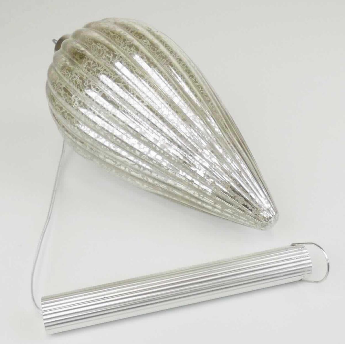 Ziergegenstand aus lampengeblasenem (gesponnenem) Glas, sog. Glaszapfen, Foto siehe Anlage,
- in Form einer zusammengesetzten Ware, bestehend aus:
- - einem oben offenen, zapfenförmigen, ca. 20 cm langen Hohlkörper aus Glas mit Rillenstruktur:
- - - laut Antrag aus lampengeblasenem Glas,
- - - innen teilweise (mit Aussparungen) silberfarben verspiegelt,
- - einem Krönchen aus unedlem Metall:
- - - den Abschluss des Zapfens bildend,
- - einem elektrischen Beleuchtungskörper: 
- - - in Form einer LED-Lichterkette, die ebenfalls in den Glaszapfen eingelegt ist,
- - - mit einer ca. 40 cm langen Zuleitung, die am oberen Ende mit einem integrierten Batteriefach und einem 
      Ein-/Ausschalter ausgestattet ist; am Ende des Batteriefachs mit einer Aufhängevorrichtung versehen,
- stellt sich insgesamt nicht als Beleuchtungskörper der Position 9405 dar, da die LED-Lichterkette im einge-
  schalteten Zustand lediglich die Zierwirkung des (charakterbestimmenden) Zapfens erhöht, die auch im
  ausgeschalteten Zustand gegeben ist,
- in einer Blisterverpackung.

"Ziergegenstand aus lampengeblasenem (gesponnenem) Glas"