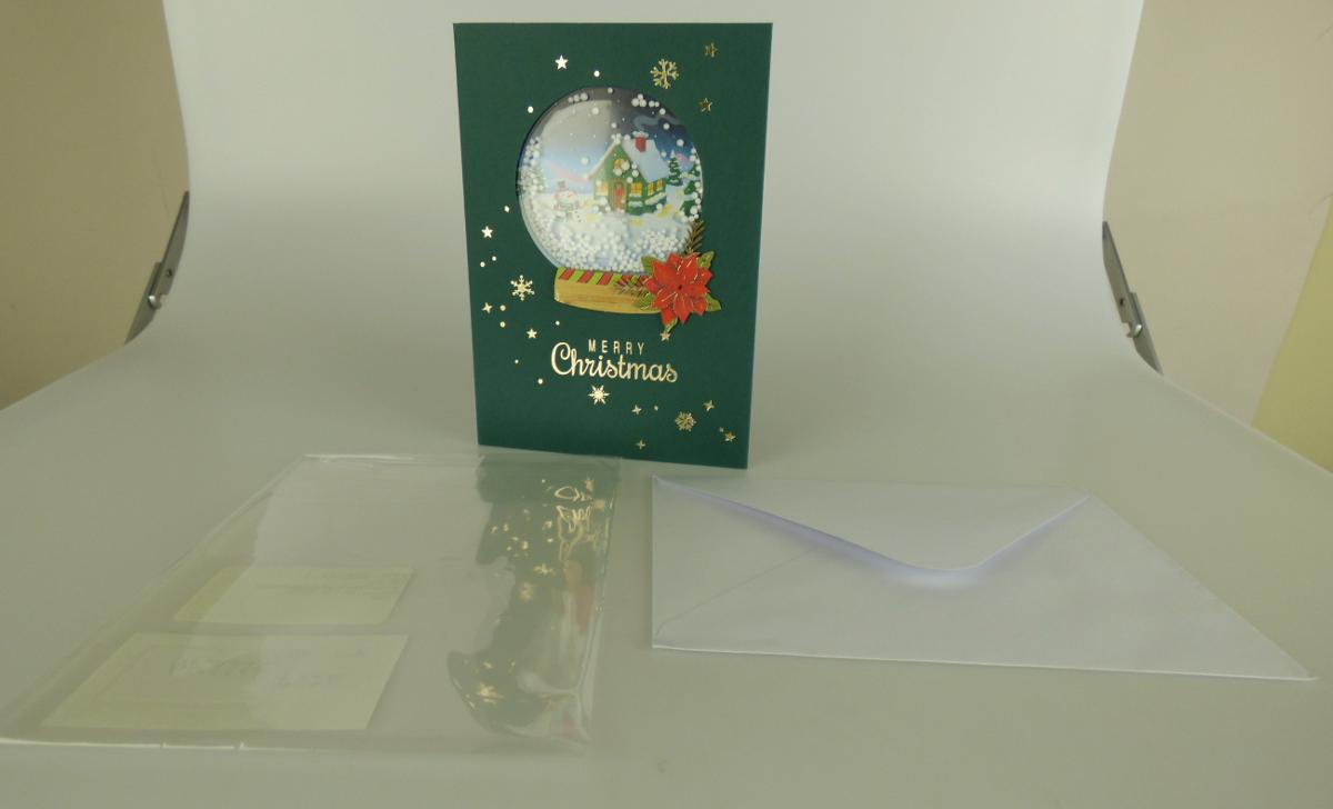 Es handelt sich um eine Klappkarte aus Kartonpapier (Format im zusammengeklappten Zustand: etwa 12 x 17 cm). Sie ist auf der Vorderseite mit winterlichen Motiven (z. B. Sterne, Schneeflocken) sowie mit dem dem Schriftzug "Merry Christmas" bedruckt und mit einem weihnachtlich dekorierten Schüttelfenster verziert. Die Weihnachtskarte ist gemeinsam mit einem passenden Briefumschlag aus Papier in einem Tütchen aus klarsichtiger Kunststofffolie verpackt.

Abbildung siehe Anlage.

Derartige Waren gehören als "Glückwunschkarten, auch illustriert, auch mit Umschlägen oder Verzierungen aller Art" zur Codenummer 4909 00 00 00 0 des Zolltarifs.