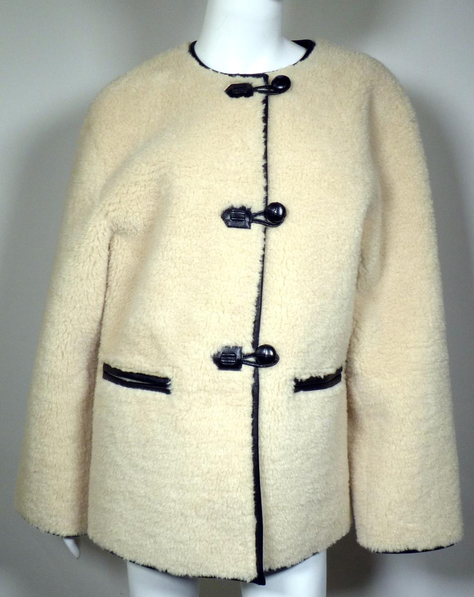Kurzmantel, Style 14961704715, Größe 38, Foto siehe Anlage,
- aus ca. 9 mm dicken, durch Kleben miteinander verbundenen Flächenerzeugnissen mit einer
  charakterbestimmenden Außenlage aus Plüschgewirken aus laut Antrag 100 % Polyester (synthe-
  tische Chemiefasern) und einer Innenlage aus einer geprägten Folie aus Zellkunststoff (laut Antrag
  Polyurethan), die auf der Innenseite mit einem Gewirke aus Spinnstoffen verstärkt ist (Meterware
  des Kapitels 39),
- über den Schritt, jedoch nicht bis zur Mitte der Oberschenkel reichend (Rückenlänge: ca. 74 cm); 
  u. a. aufgrund der Länge kein Mantel oder Parka,
- mit einem runden Halsausschnitt,
- vorn mit einer durchgehenden Öffnung mit Knopf- und Schlaufenverschluss von rechts auf links
  (Frauenkleidung),
- mit langen Ärmeln,
- mit zwei eingesetzten, offenen Taschen unterhalb der Taille,
- mit Randeinfassungen aus der o. g. Meterware des Kapitels 39,
- wird im Allgemeinen über jeder anderen Kleidung und zum Schutz gegen das Wetter getragen, 
- erfüllt aufgrund der Länge in Verbindung mit dem Material (Art und Dicke des Flächenerzeugnisses)
  die Voraussetzungen zur Einreihung als Kurzmantel, u. a. somit keine Jacke der Position 6104,
  aufgrund dere verwendeten Flächenerzeugnisse auch keine Ware der Position 6113.

"Kurzmantel, aus Gewirken, für Frauen, aus Chemiefasern"