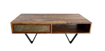 Es handelt sich bei dem sog. „Couchtisch Sheesham“ um ein aus verschiedenen Stoffen zusammengesetztes, ca. 115 x 60 x 38 cm (B x T x H) großes Möbel, bestehend aus Metallbeinen und einer Ablagefläche mit zwei darunter befindlichen Stauräumen aus Holz.

Bei der aus unterschiedlichen Stoffen bestehenden Ware wird der stoffliche Charakter weder von den Metallbeinen (Bedeutung als tragende Teile) noch von dem Korpus aus Holz (Bedeutung für die Verwendung) bestimmt. Das Erzeugnis ist in die zuletzt genannte Unterposition der gleichermaßen in Betracht kommenden Unterpositionen einzureihen.

Das Möbel ist dazu bestimmt, auf den Boden gestellt zu werden und dient als Einrichtungsgegenstand in Wohnzimmern.

Das verpackte Erzeugnis wird als „anderes als in den Positionen 9401 und 9402 erfasstes Möbel, aus Holz, von der in Wohn- und Esszimmern verwendeten Art“ eingereiht.